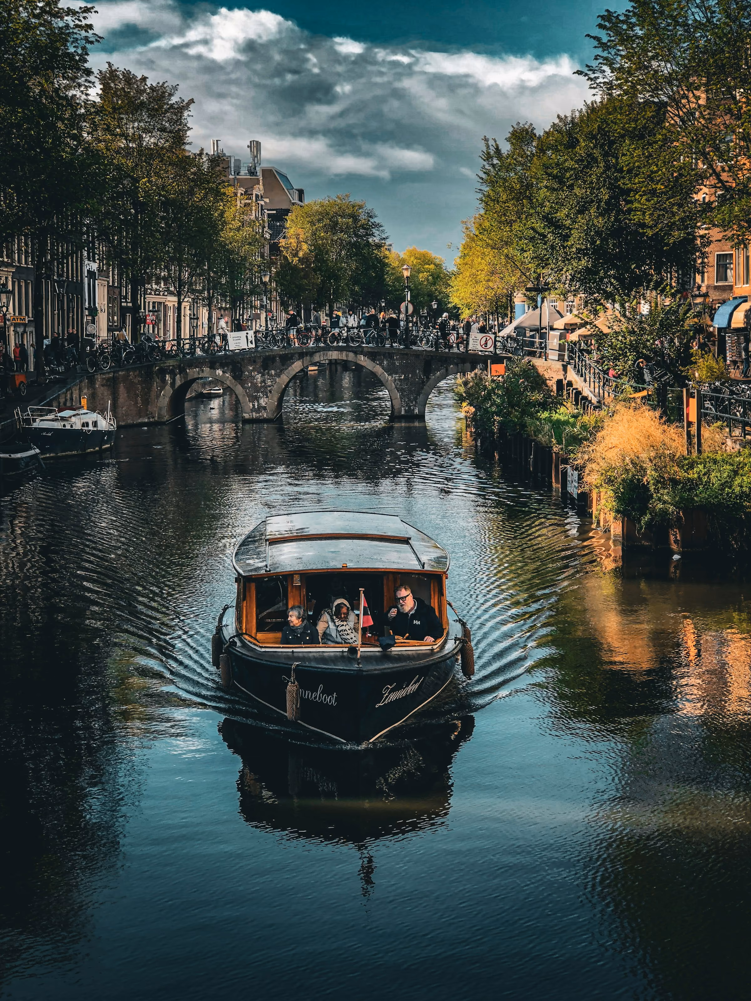 A small boat on a tree-lined Amsterdam canal