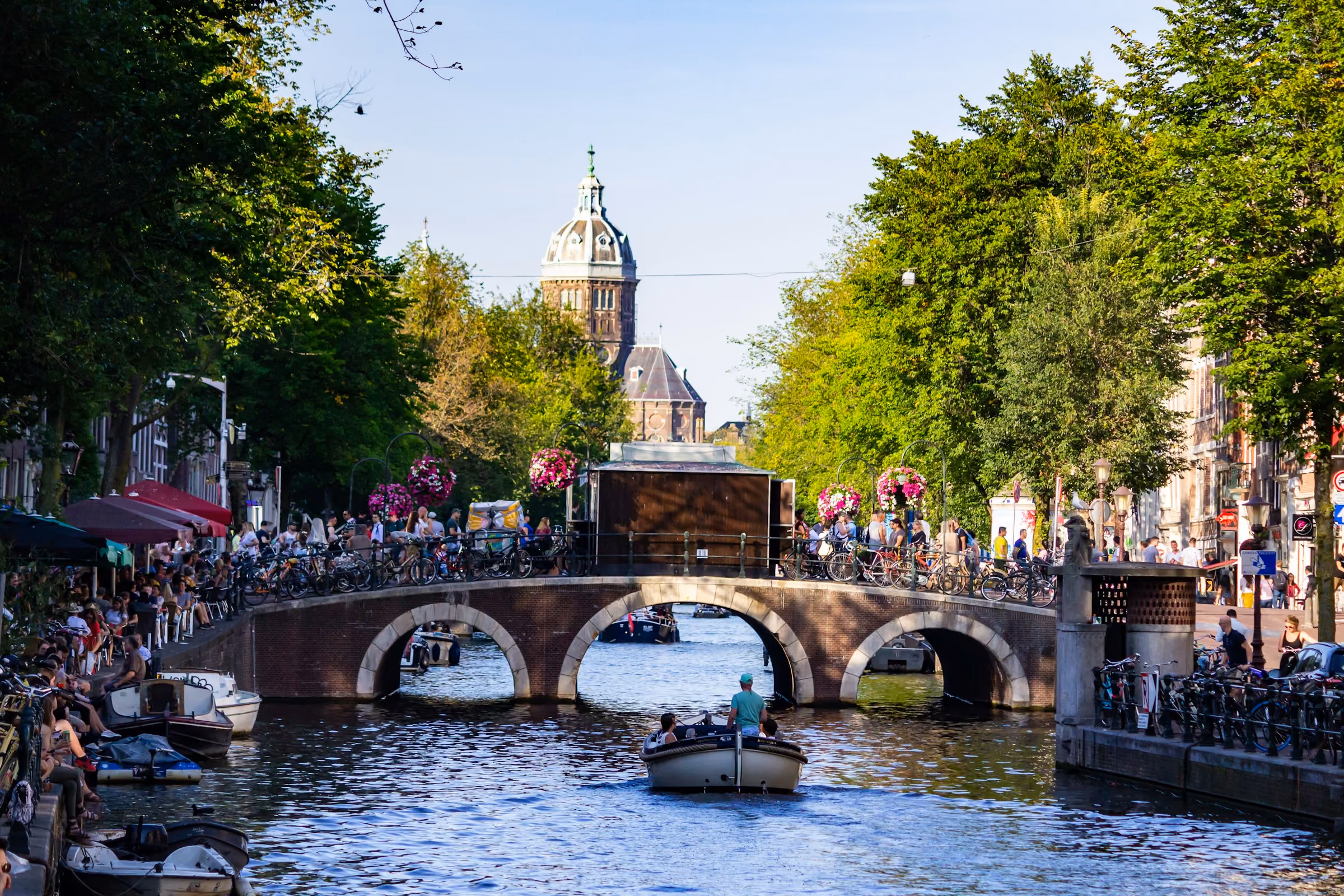 An Amsterdam canal bridge with boats passing below