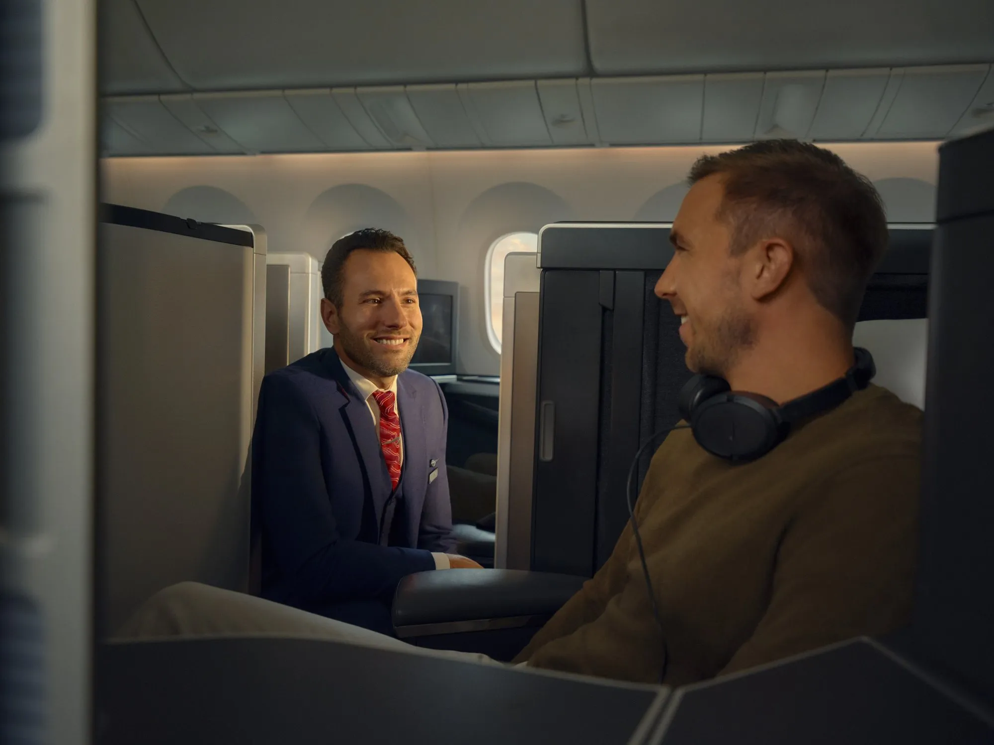 A member of BA cabin crew talking to a passenger in Club