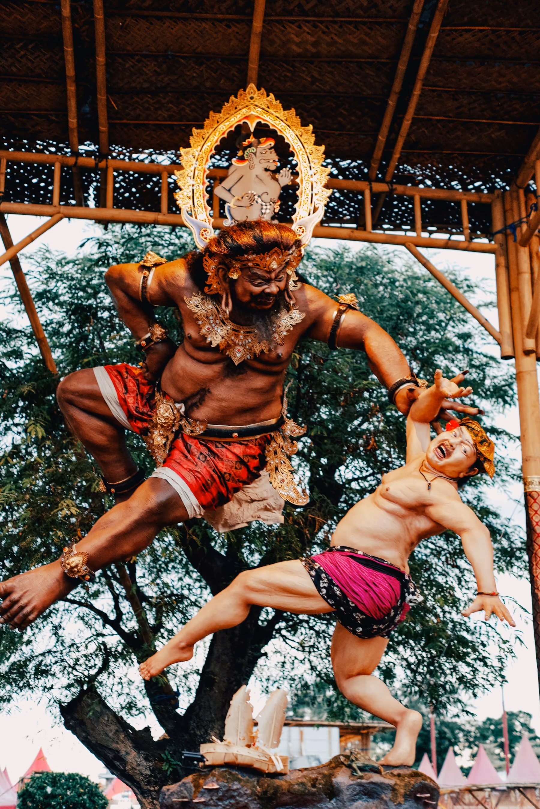 A painted ogoh-ogoh effigy of a demon and a fleeing villager, made for the parade on the eve of Nyepi