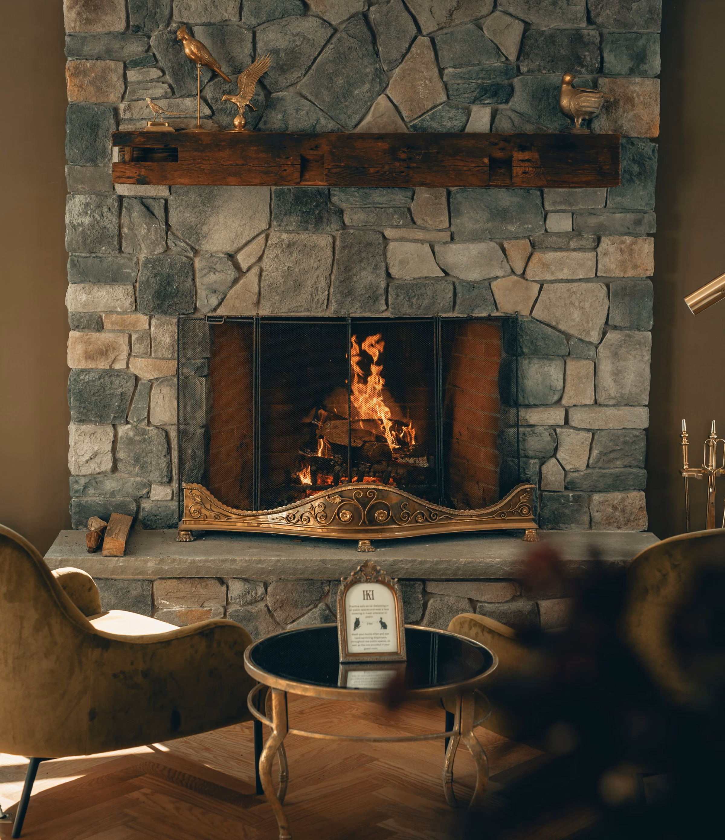A log fire burning in a stone fireplace in a cosy chalet sitting room