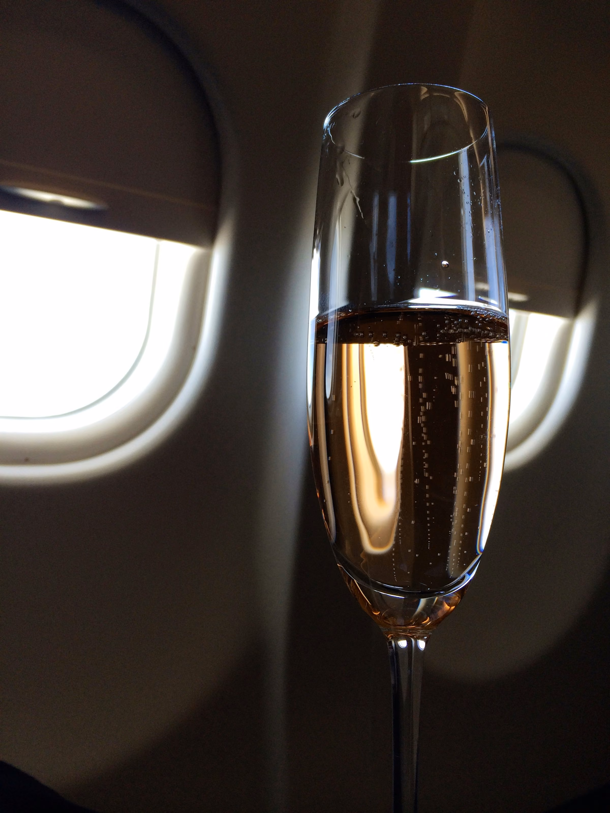 A glass of Champagne on a table by a window