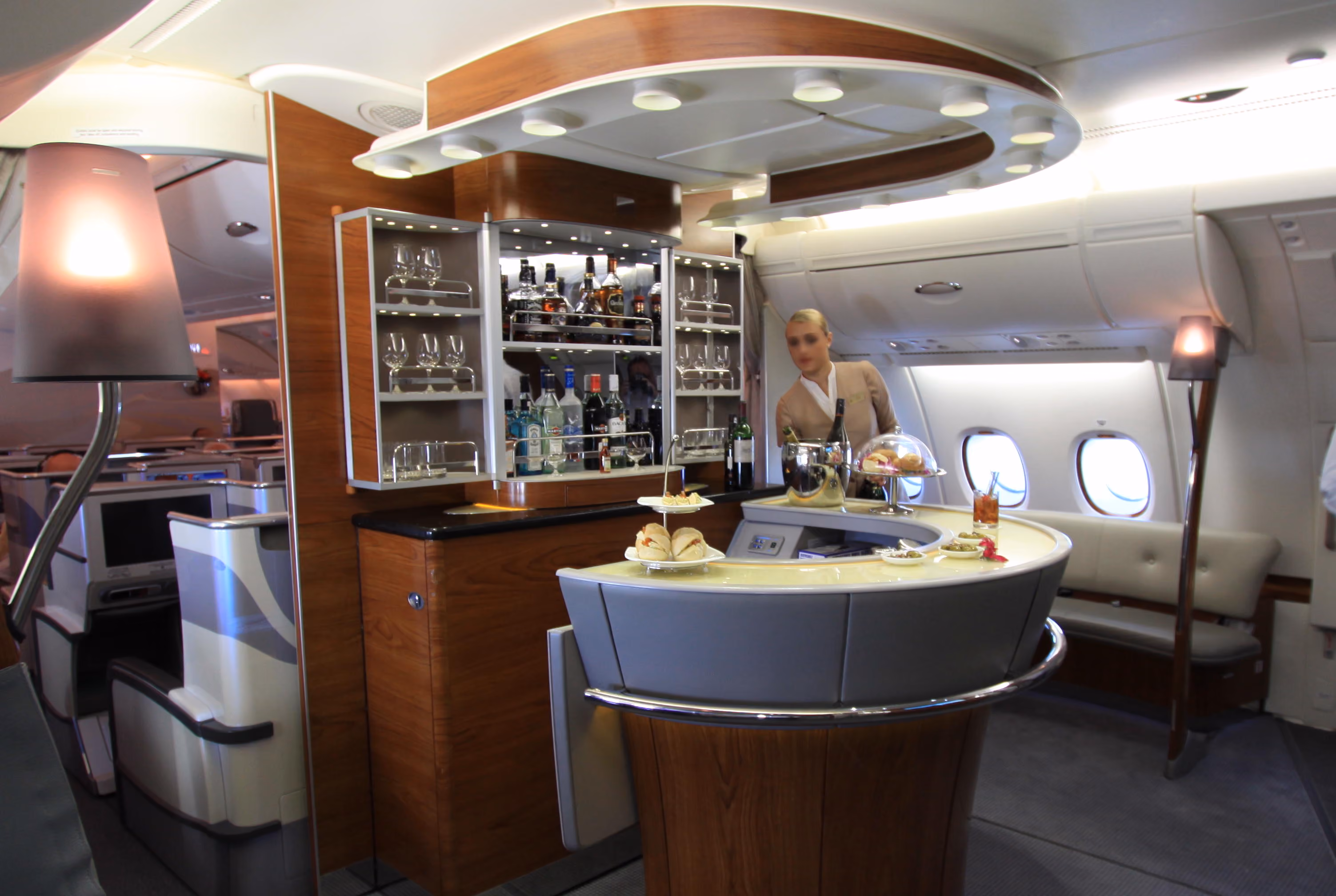 The onboard bar on an Emirates A380, with glassware, spirits and canapes laid out on the curved counter