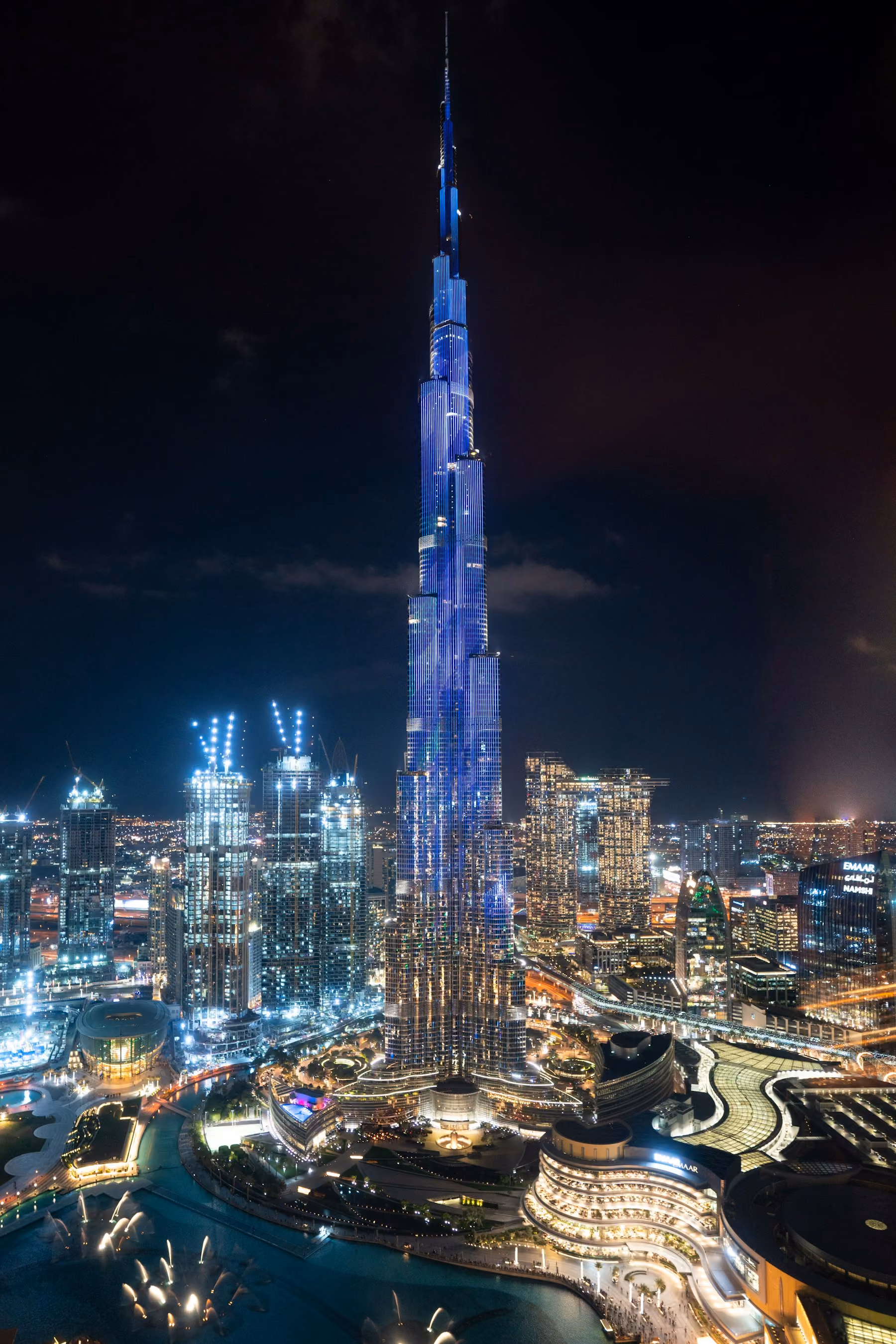 The Burj Khalifa lit in blue above Downtown Dubai at night