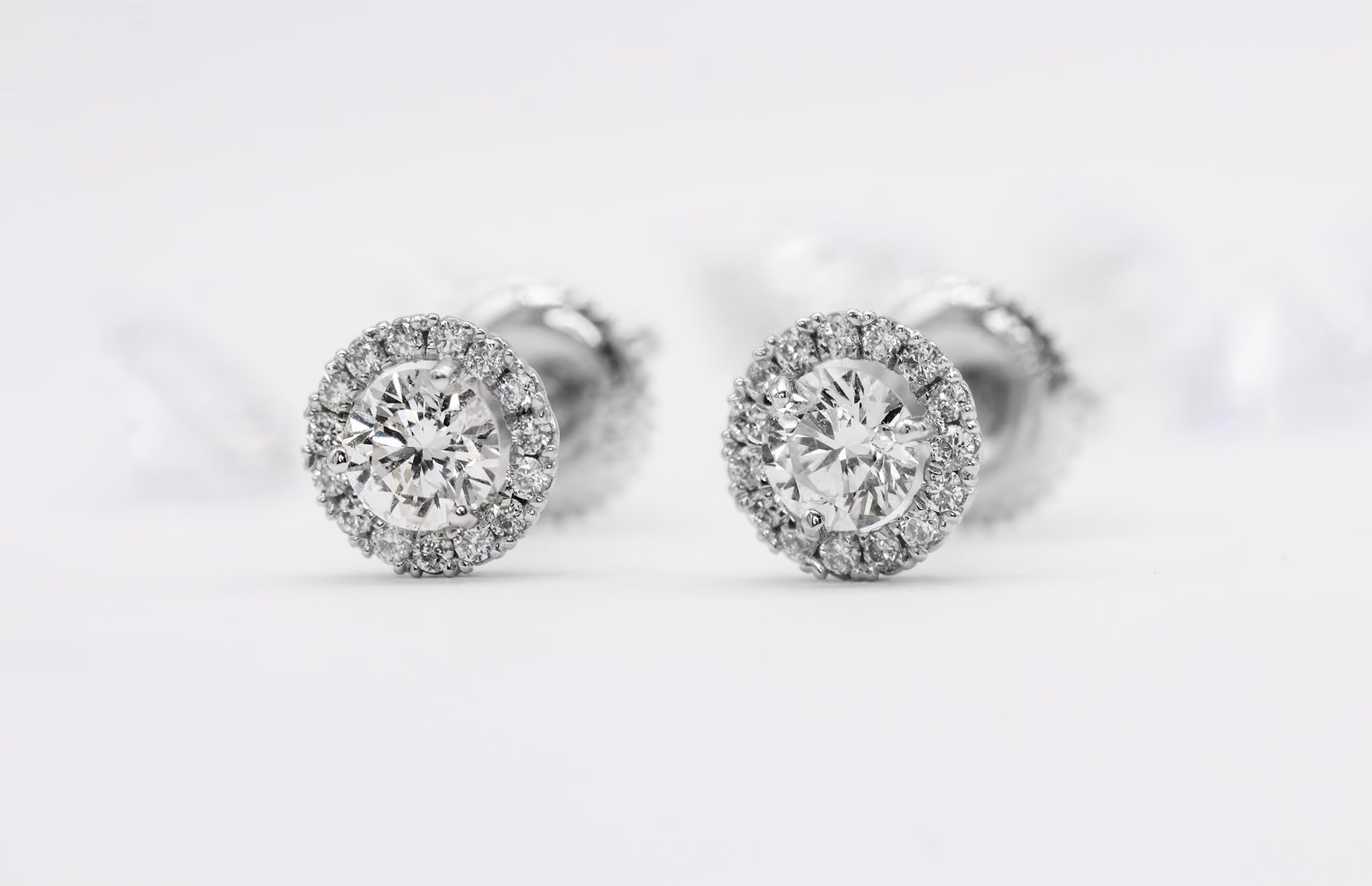 Diamond stud earrings on a pale background