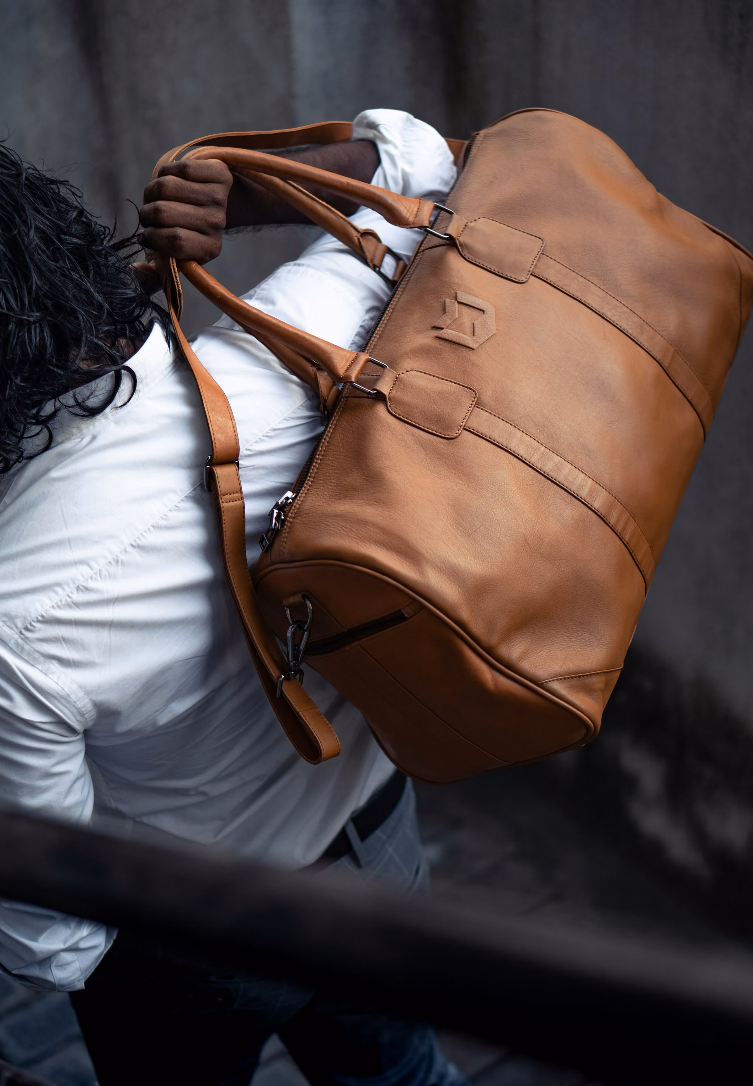 A brown leather holdall over a shoulder