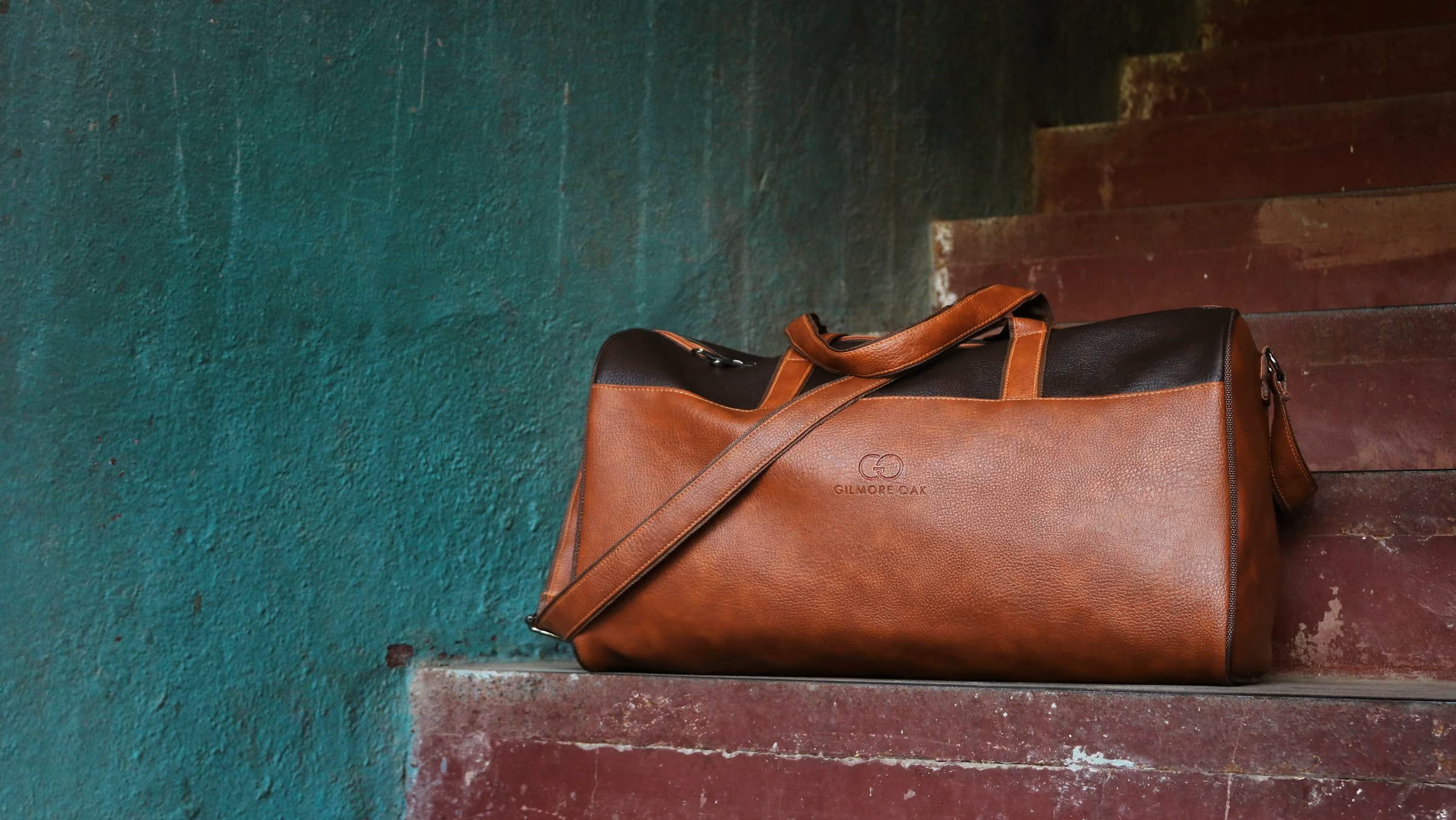 A tan leather holdall on stone steps