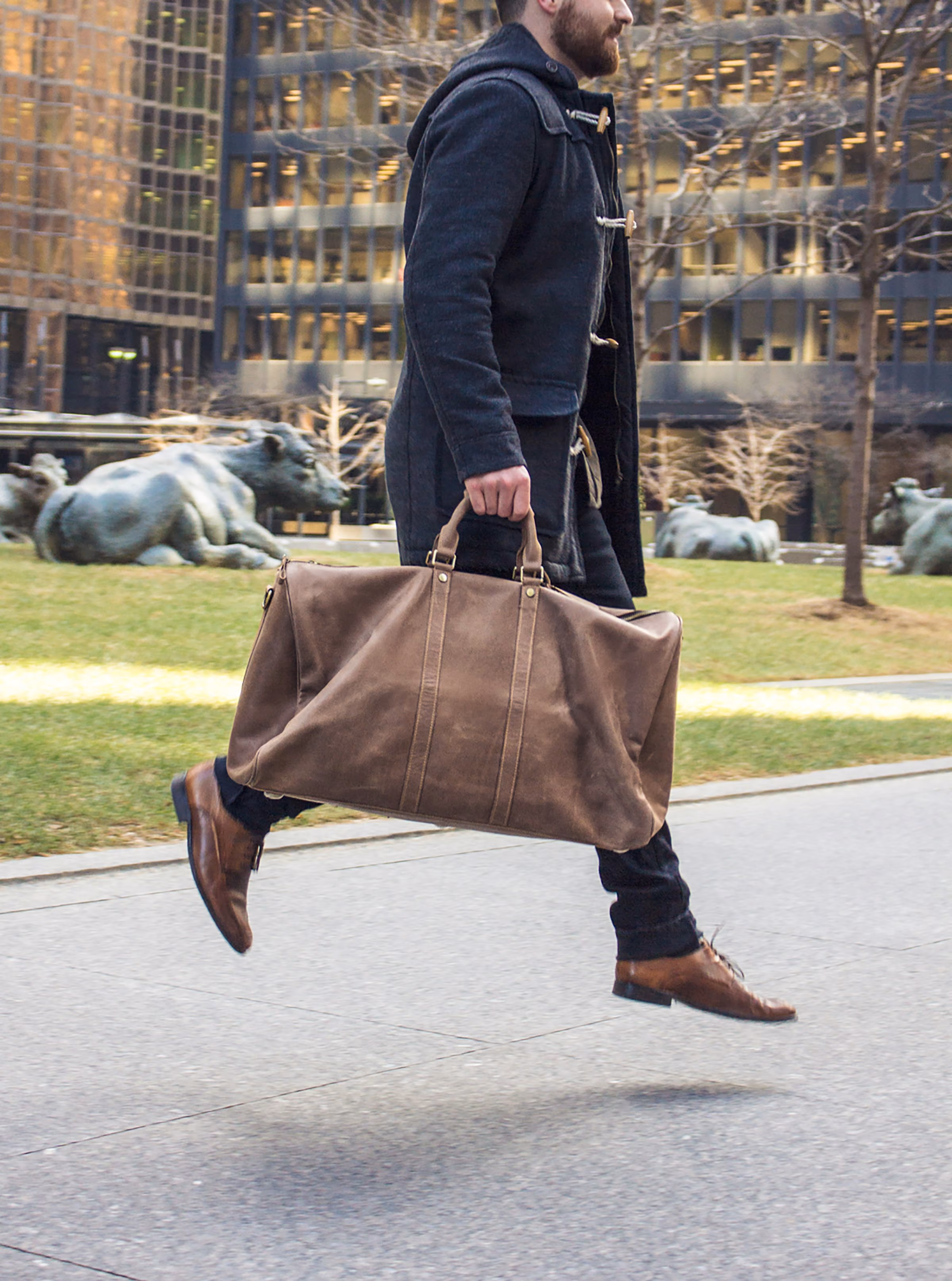 Carrying a leather weekend bag through a city