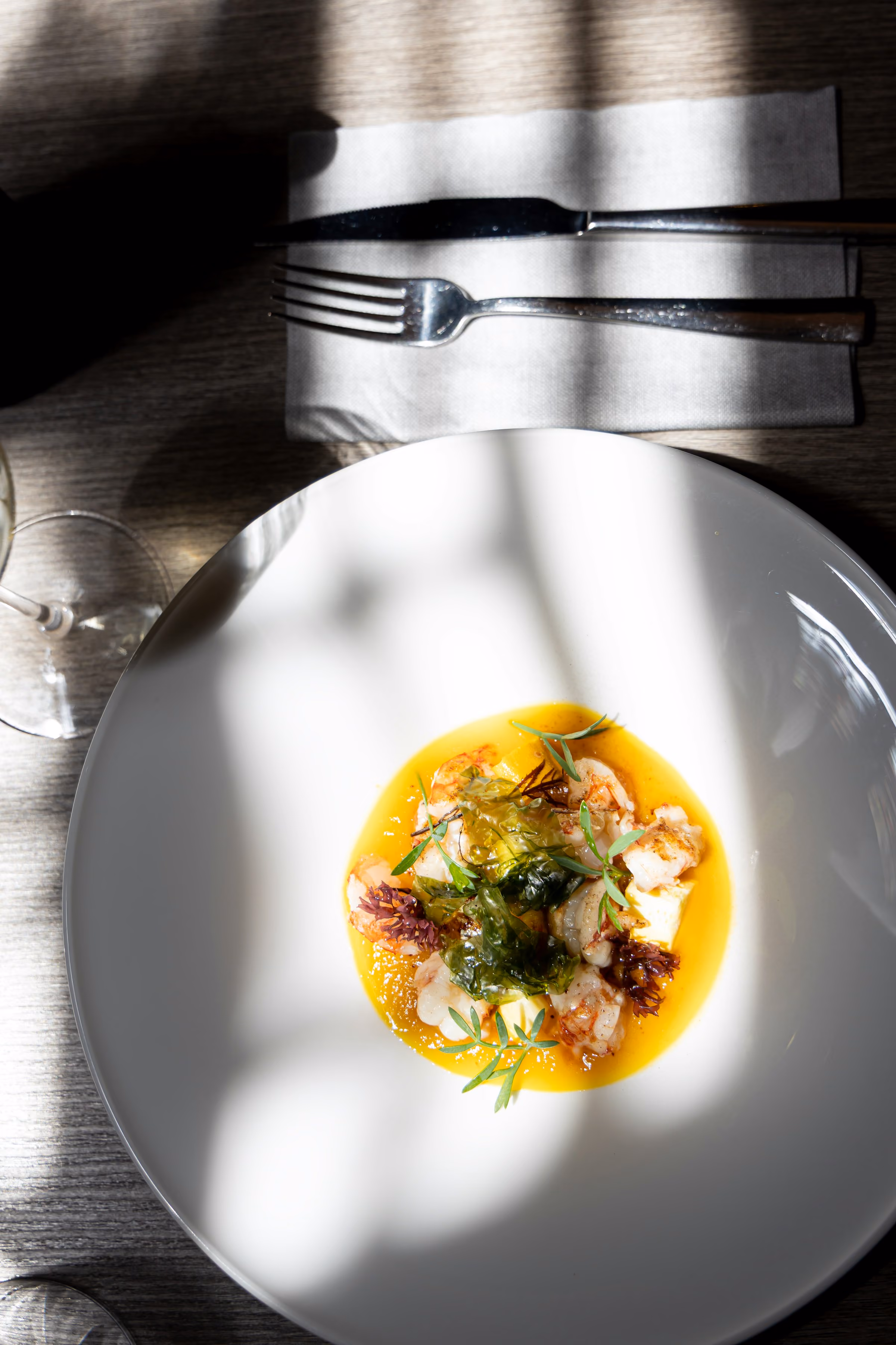 A plated course in soft window light with cutlery