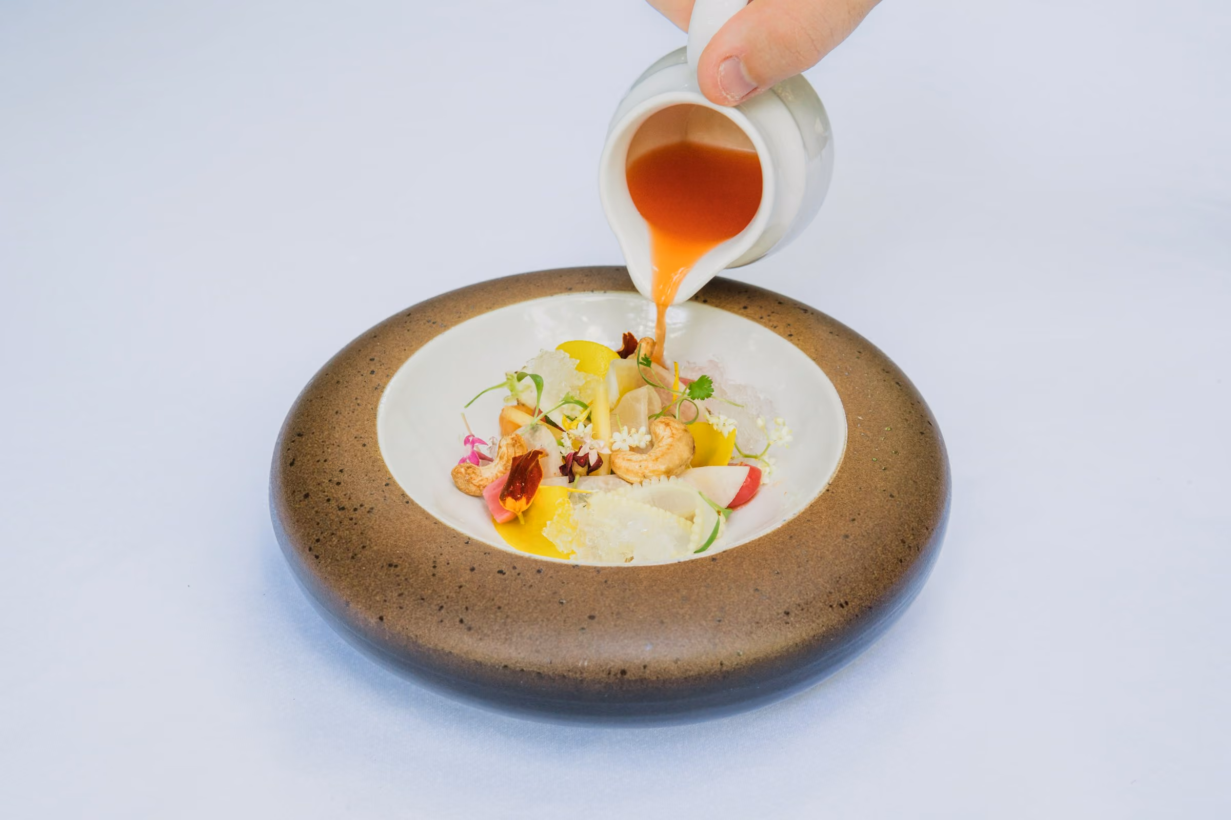 Broth poured into a bowl at the table