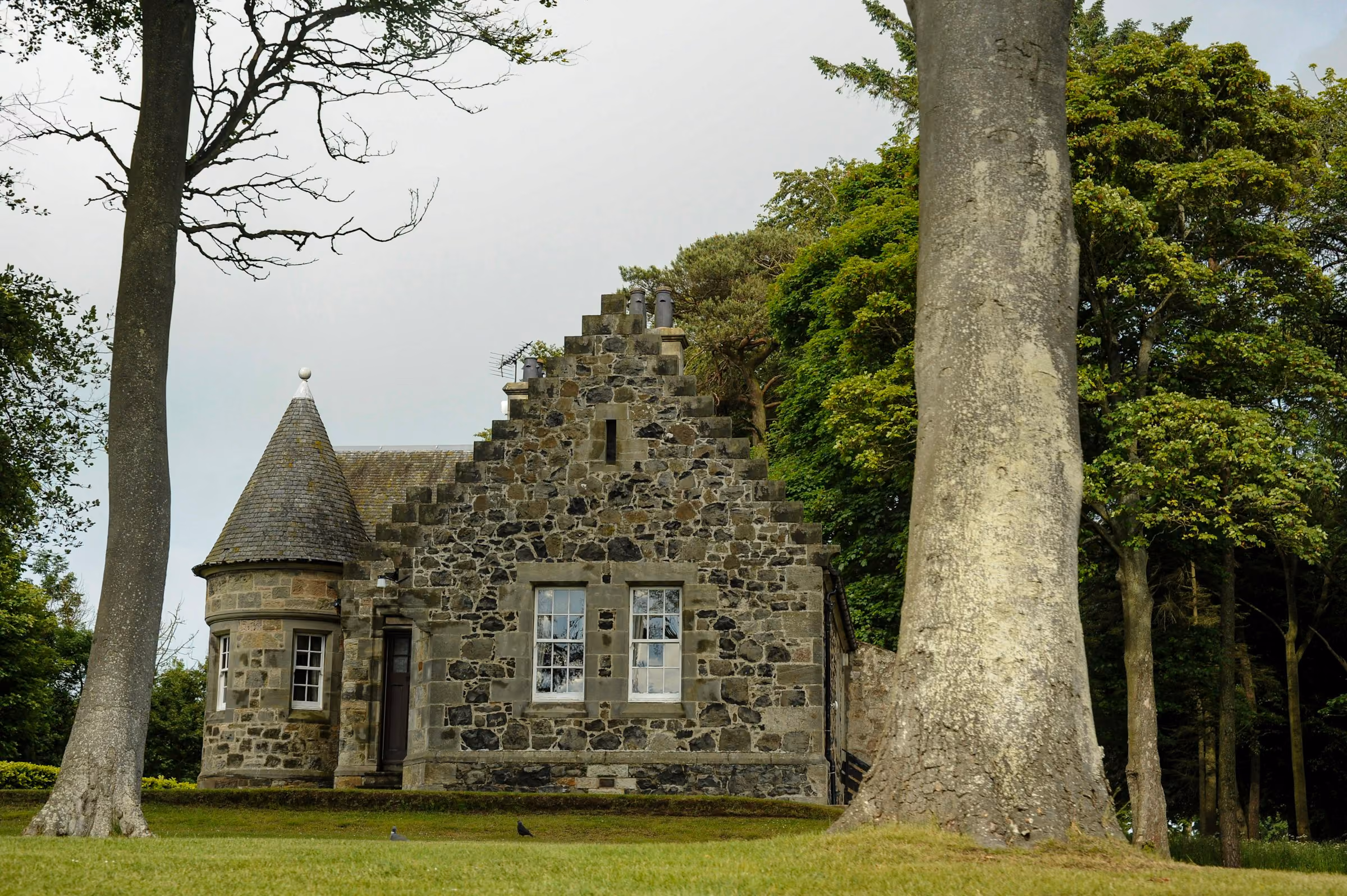 A stone lodge among tall trees in Scotland