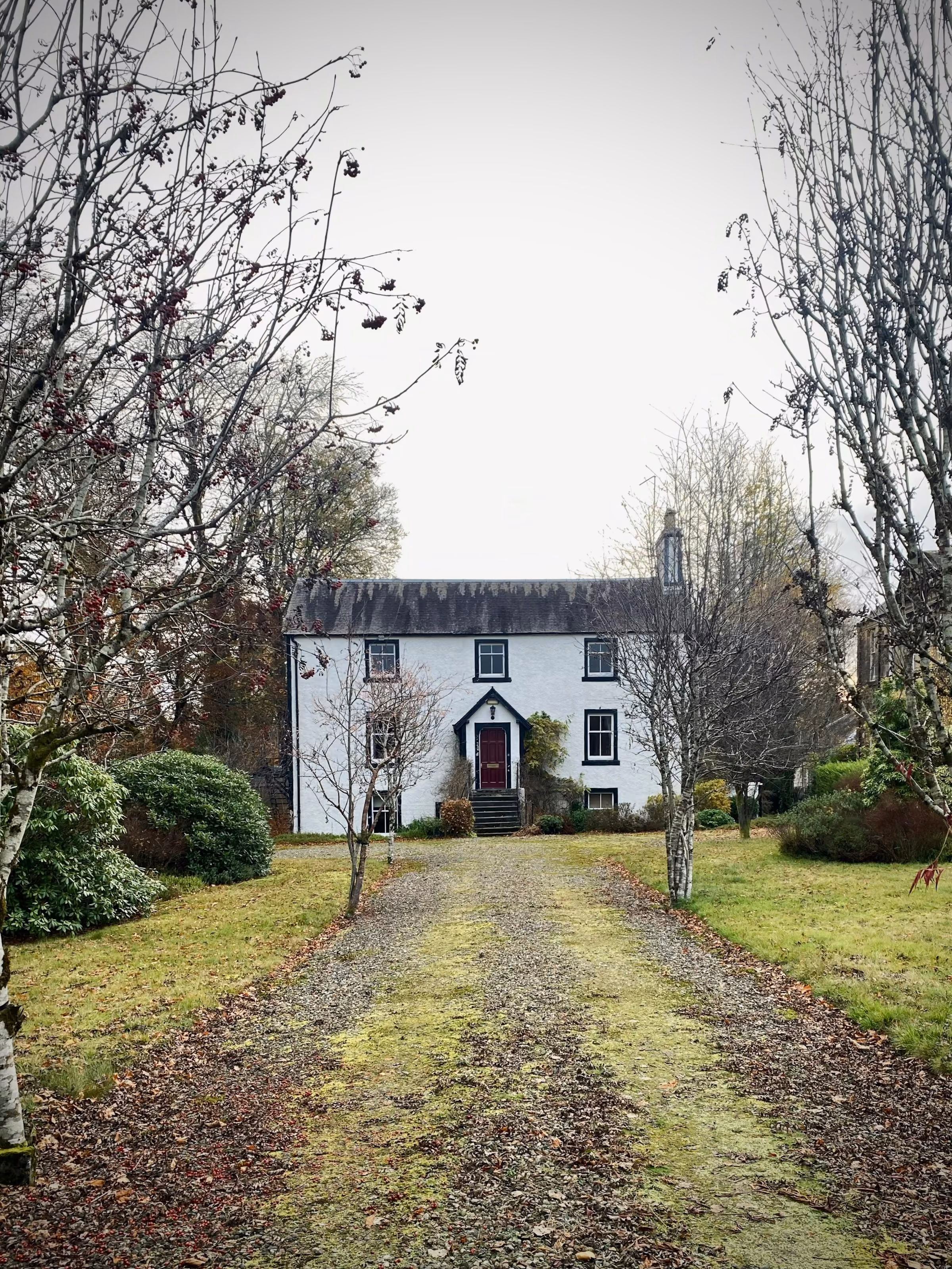 A white country house at the end of a long drive