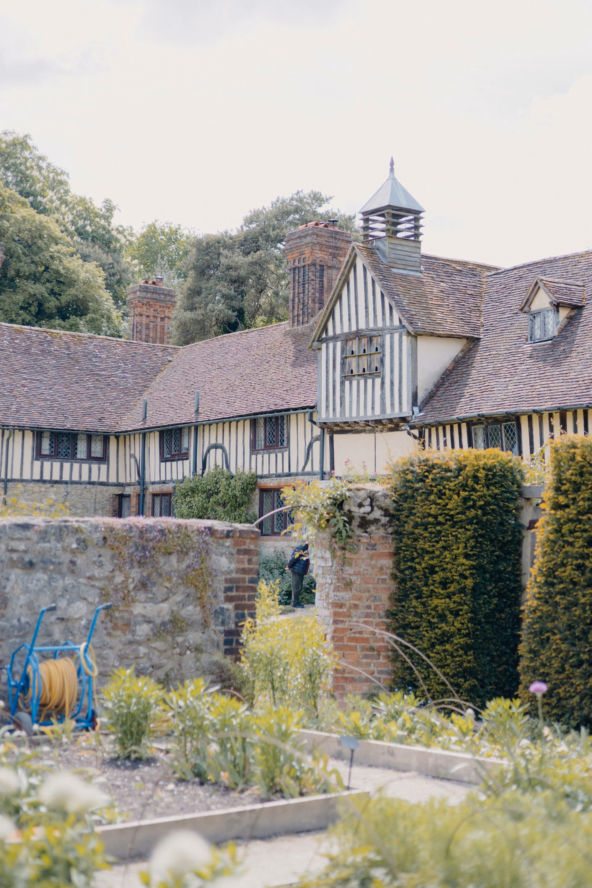 A timber-framed house above a kitchen garden
