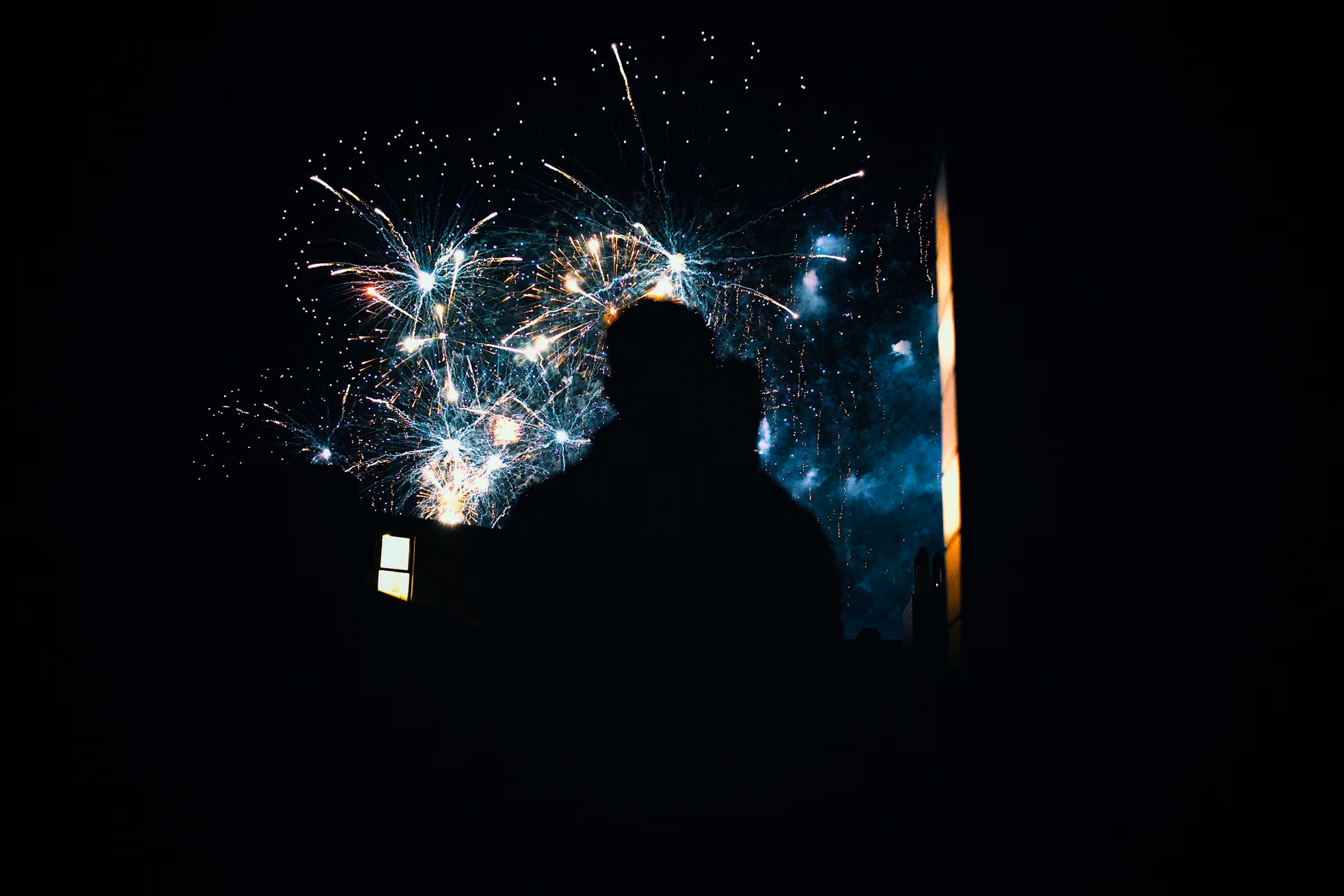 A figure watching fireworks
