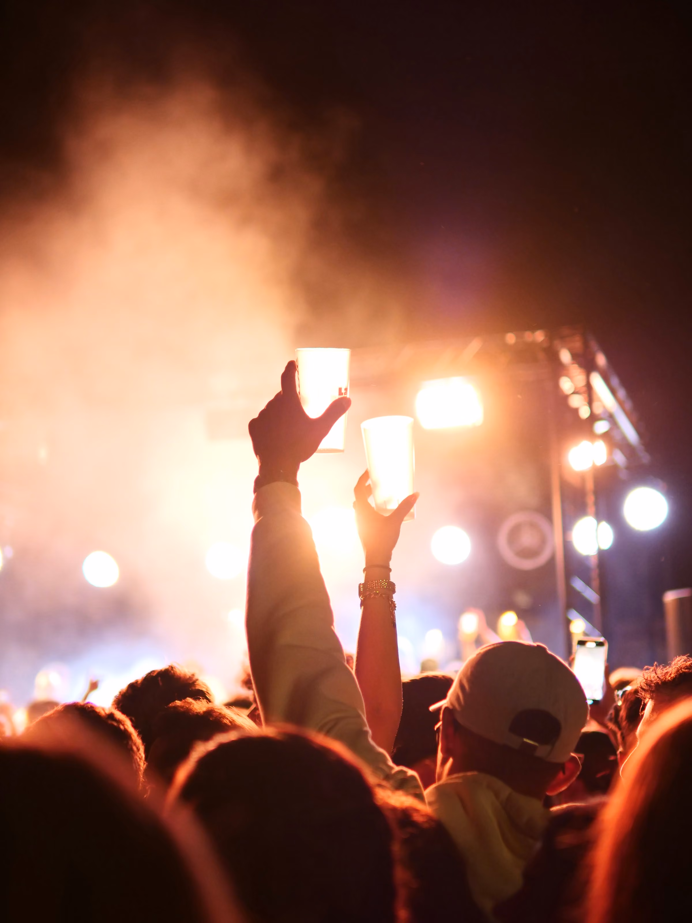 Hands raised to stage lights at a gig
