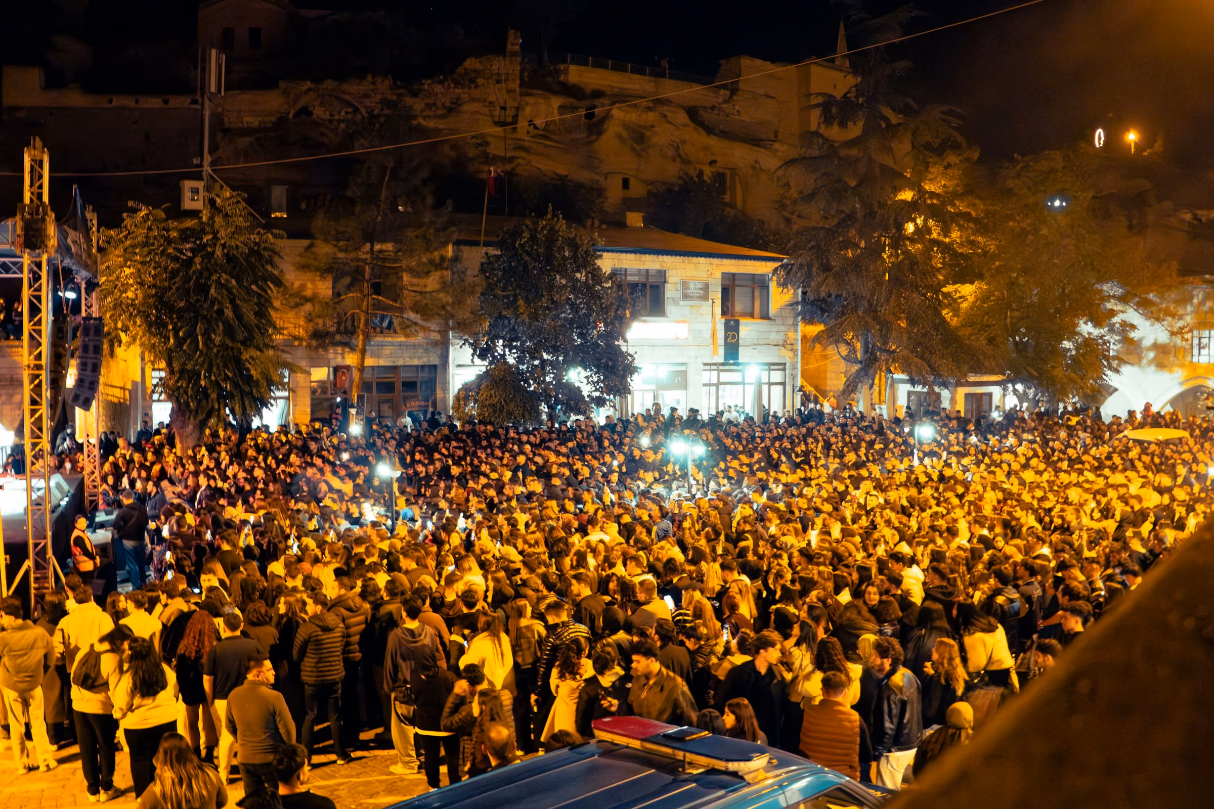 A crowd filling a square for an outdoor gig