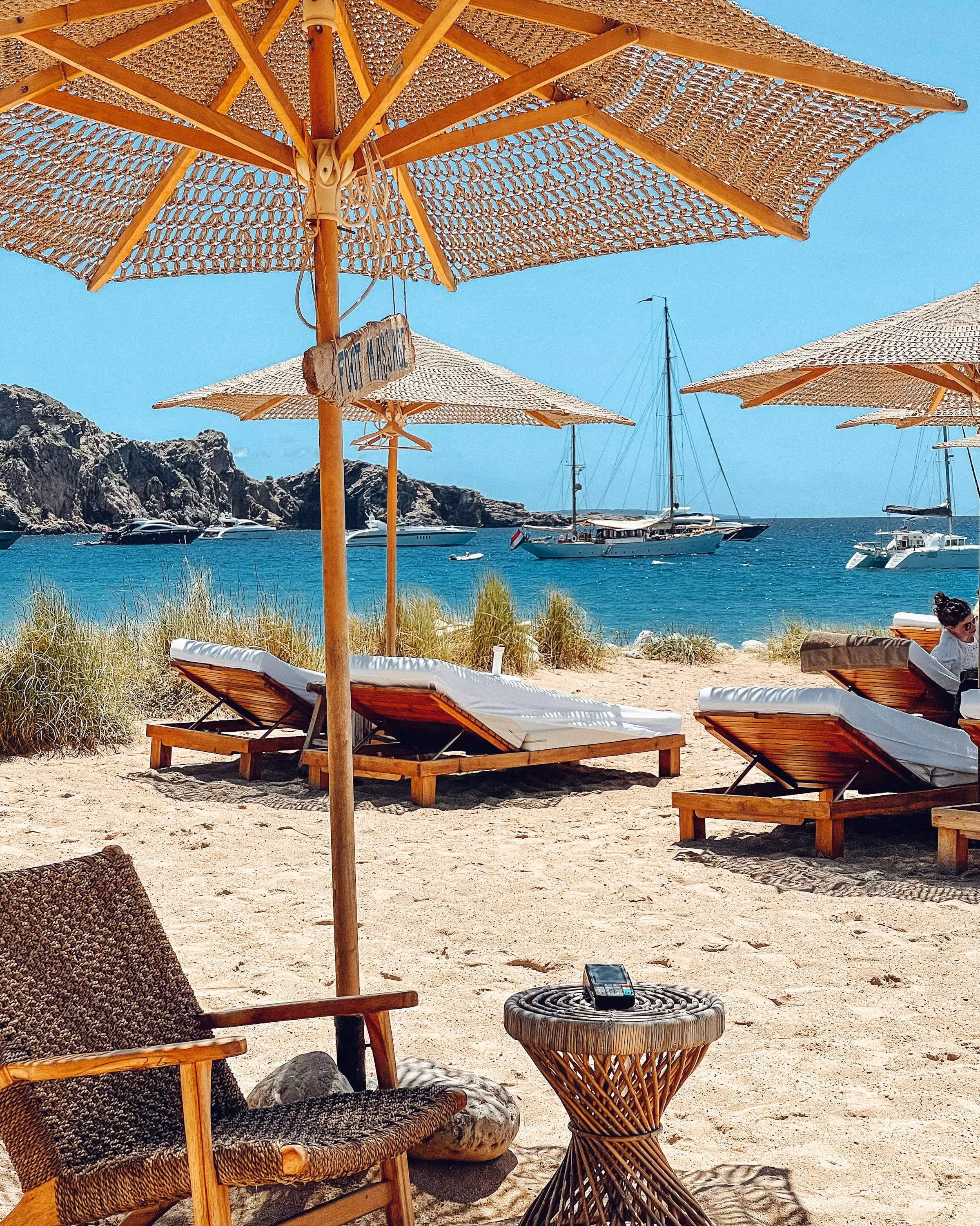 Straw umbrellas and loungers at a calm Ibiza beach club