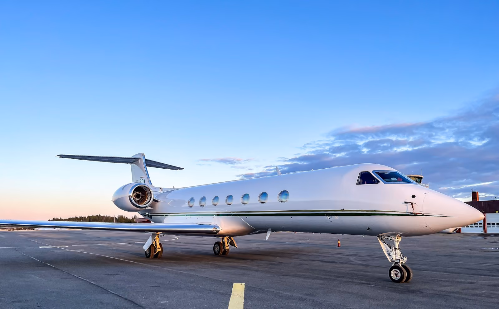 A large private jet parked on the tarmac in evening light