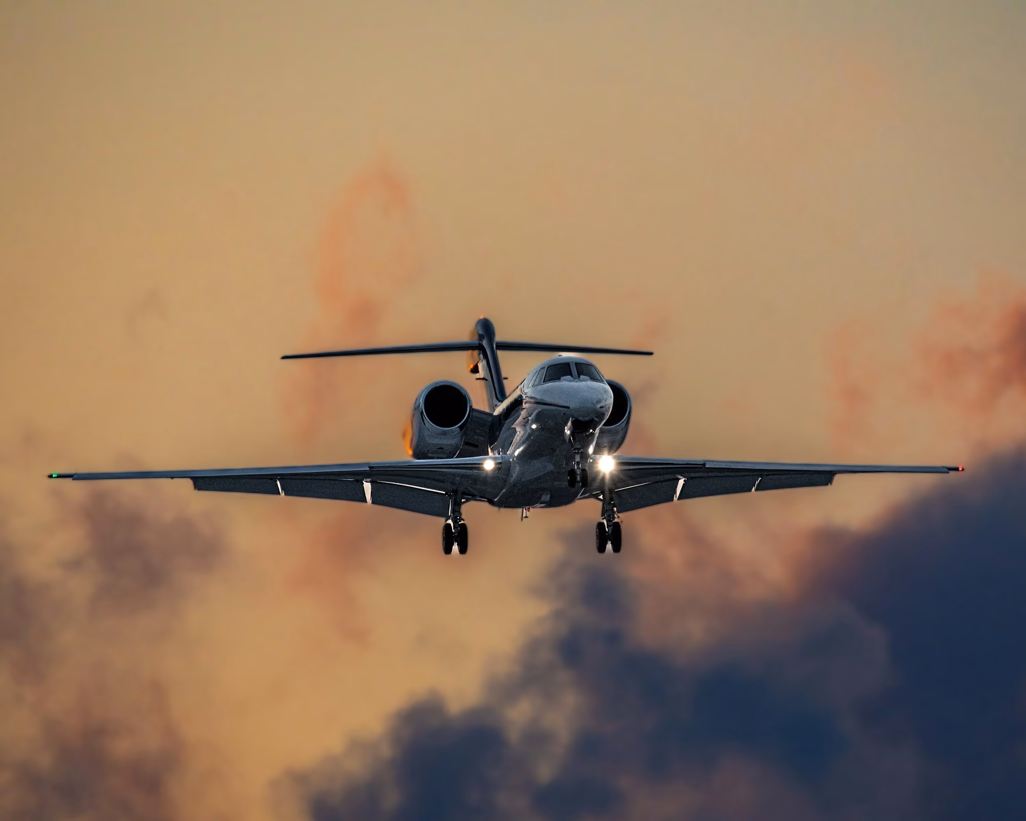 A private jet in flight against a sunset sky
