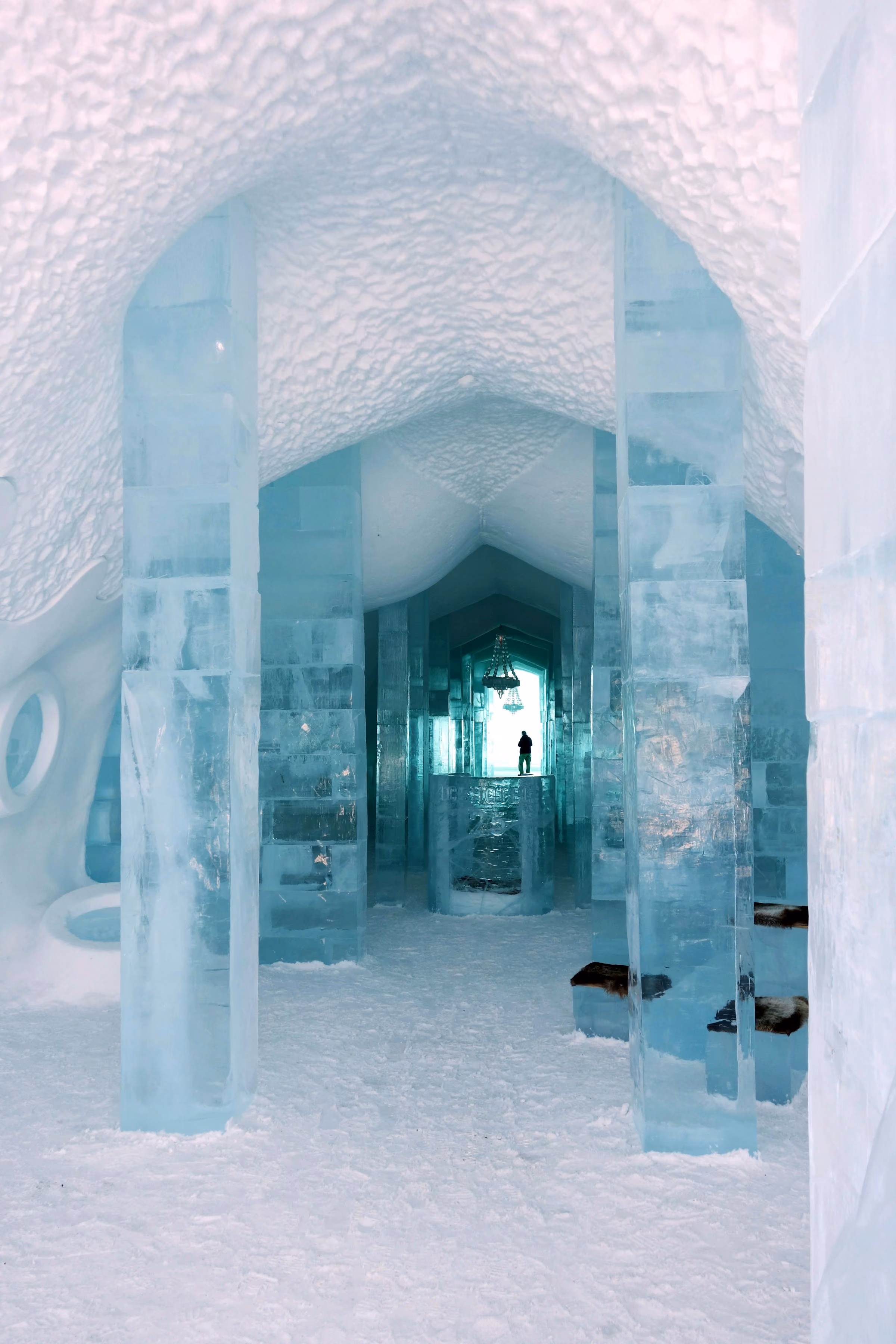 A corridor carved from ice and snow lit pale blue