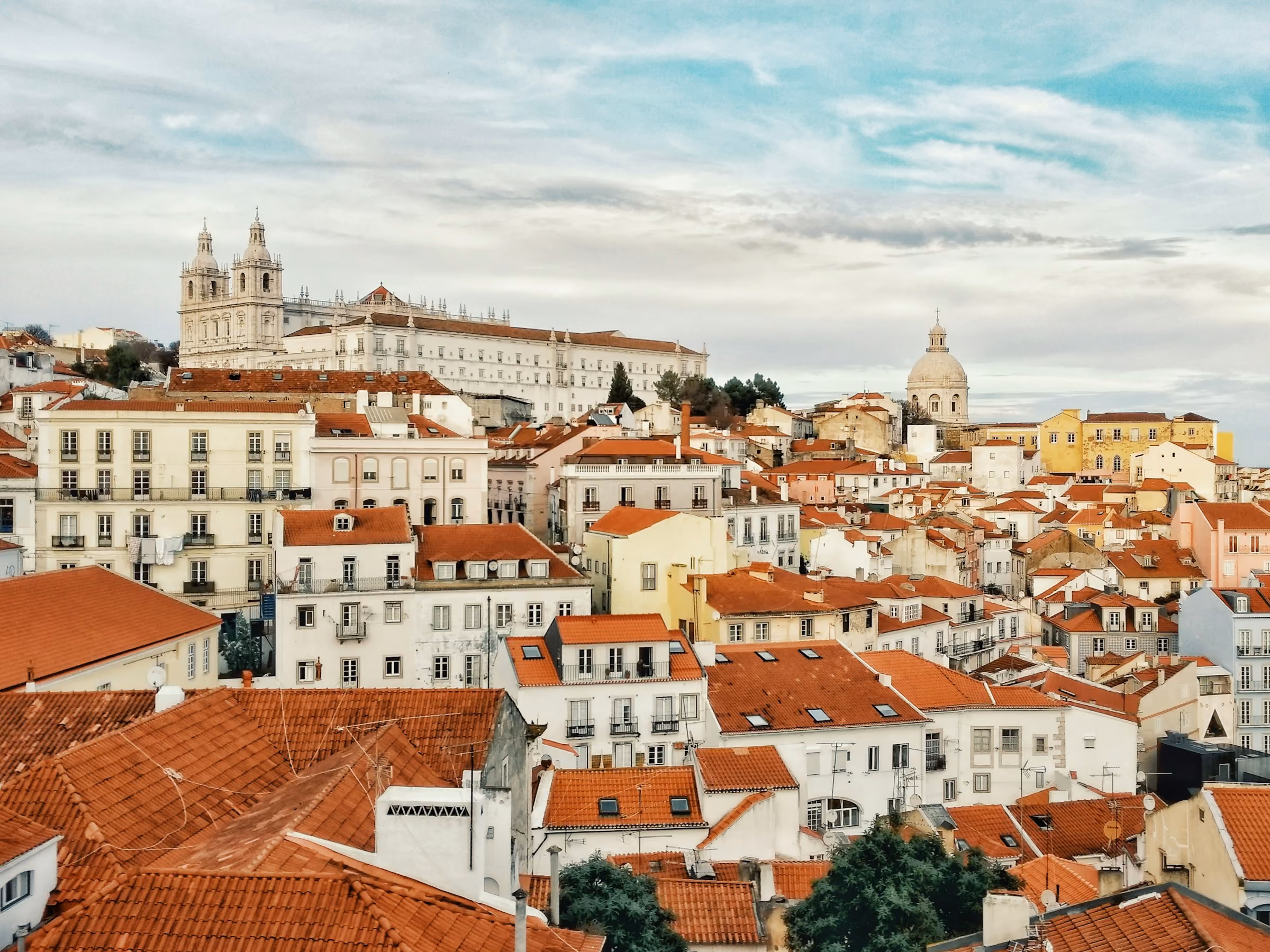 Terracotta rooftops of Lisbon's Alfama running down to the river
