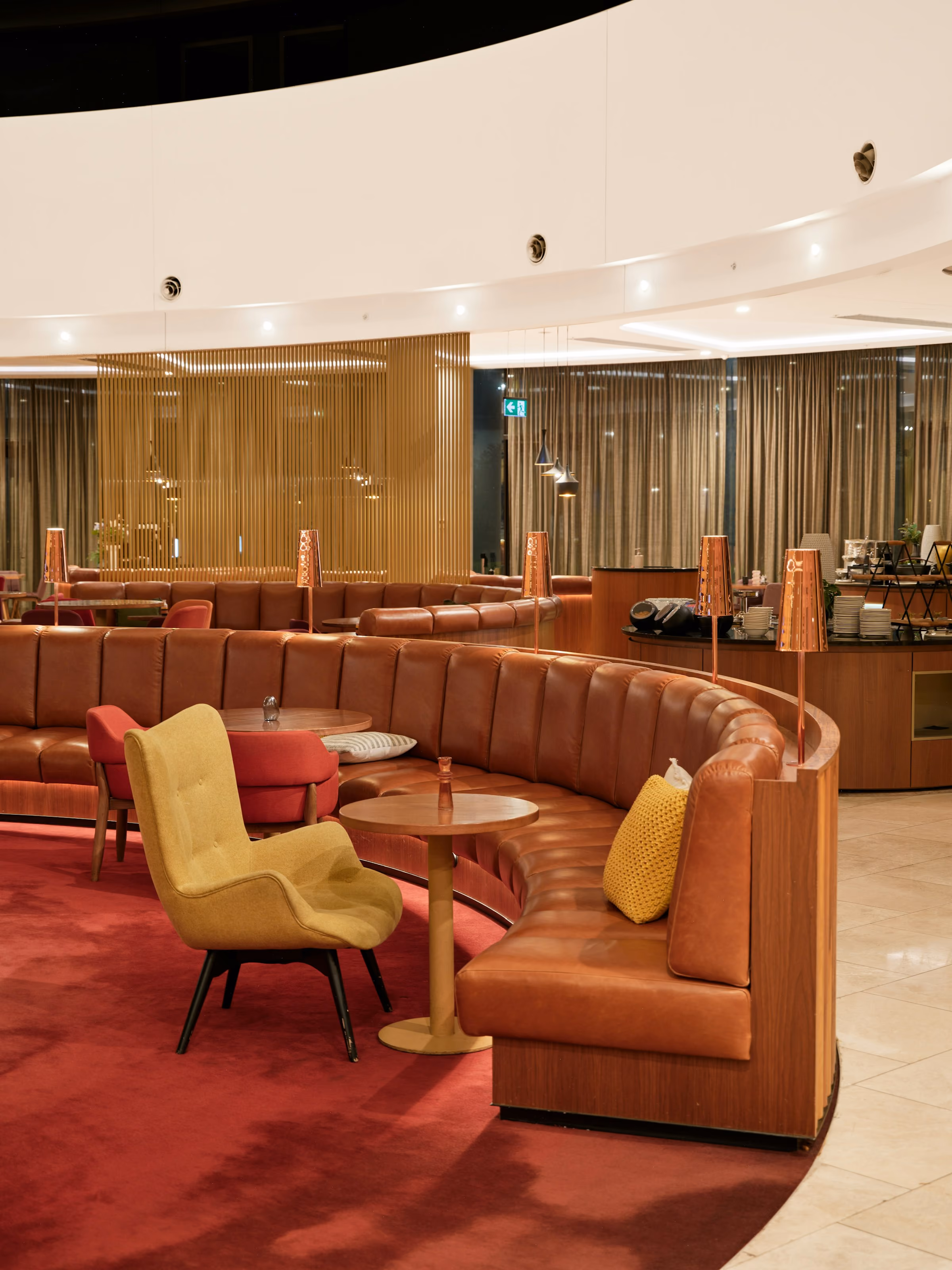Curved red sofas and armchairs in a quiet lounge