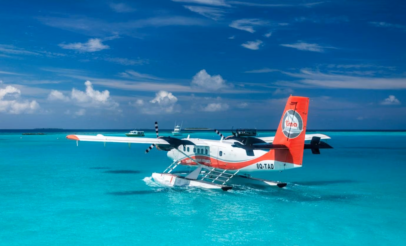 A seaplane taxiing across a turquoise Maldives lagoon