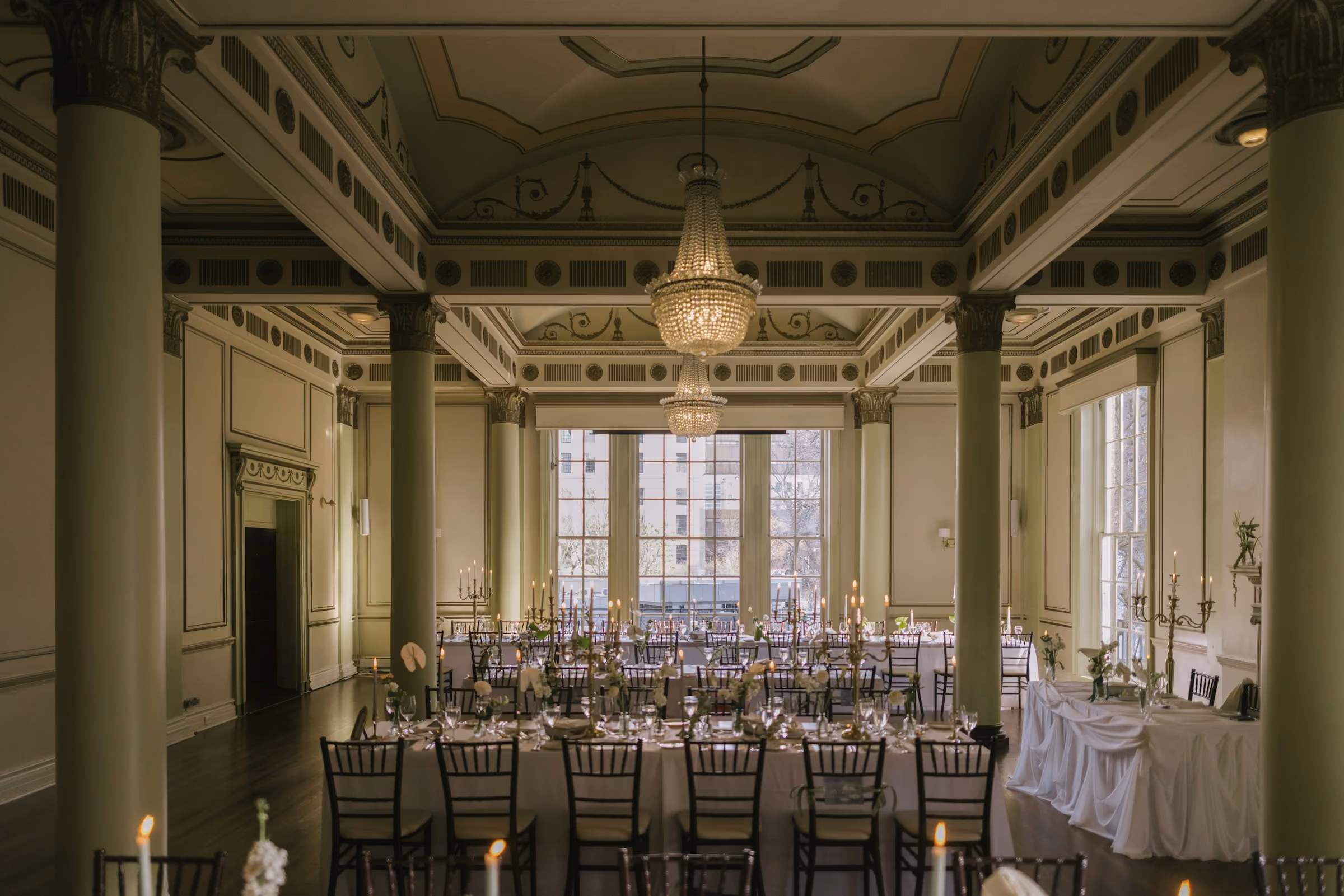 A ballroom with columns laid for a gala dinner