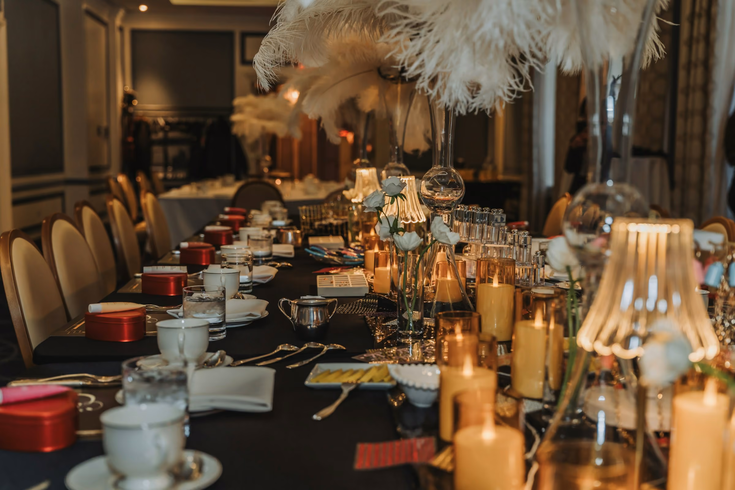 A candlelit gala table with feather centrepieces