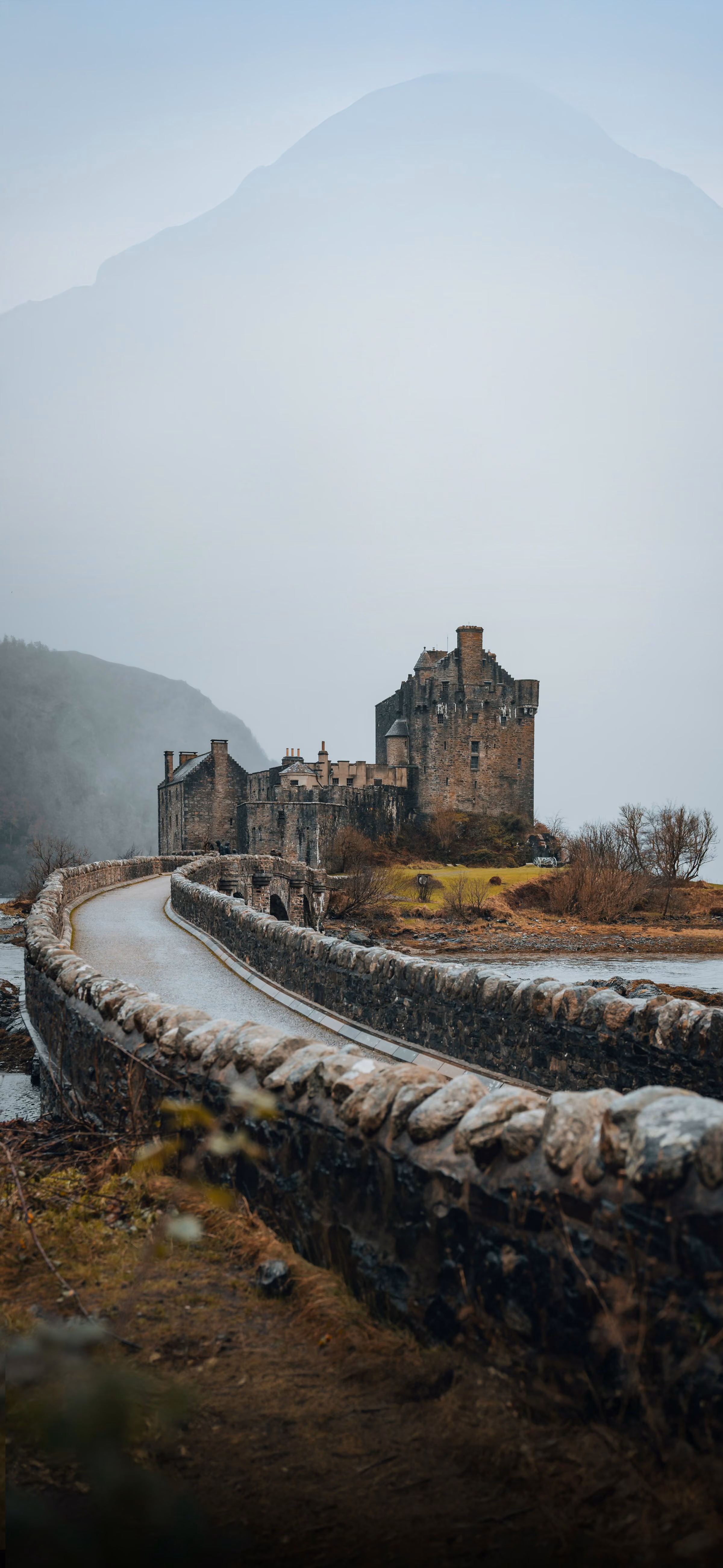 A Highland castle on a loch under mist