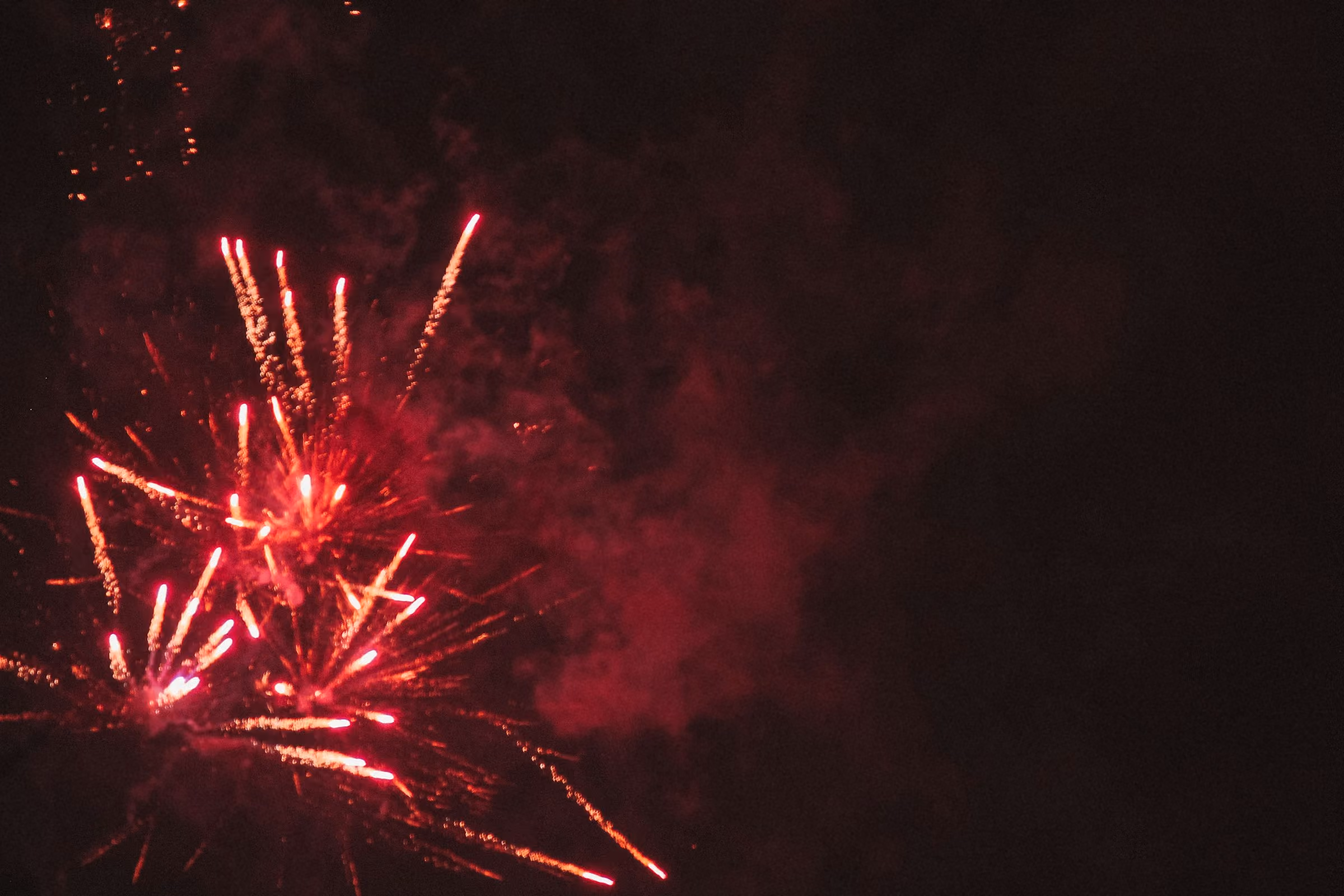 Red fireworks bursting in a night sky