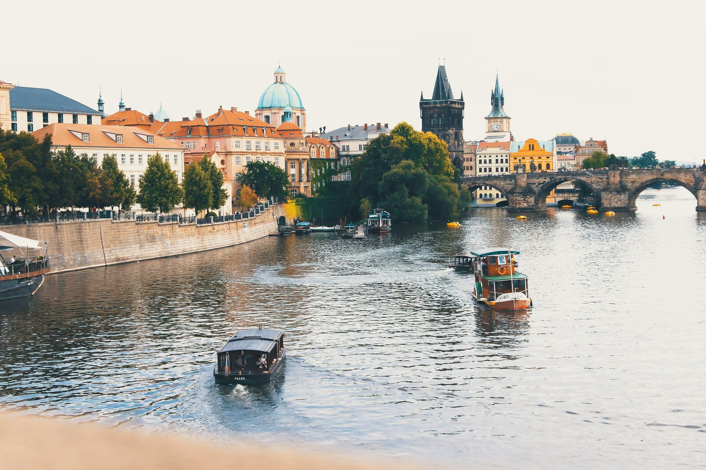 Boats on the Vltava in Prague with Charles Bridge behind