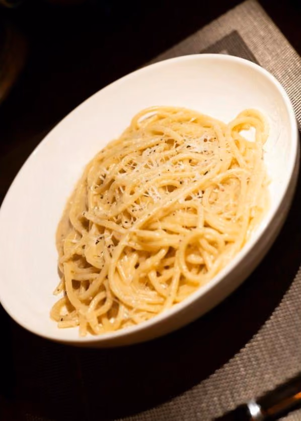 A bowl of cacio e pepe dusted with pecorino