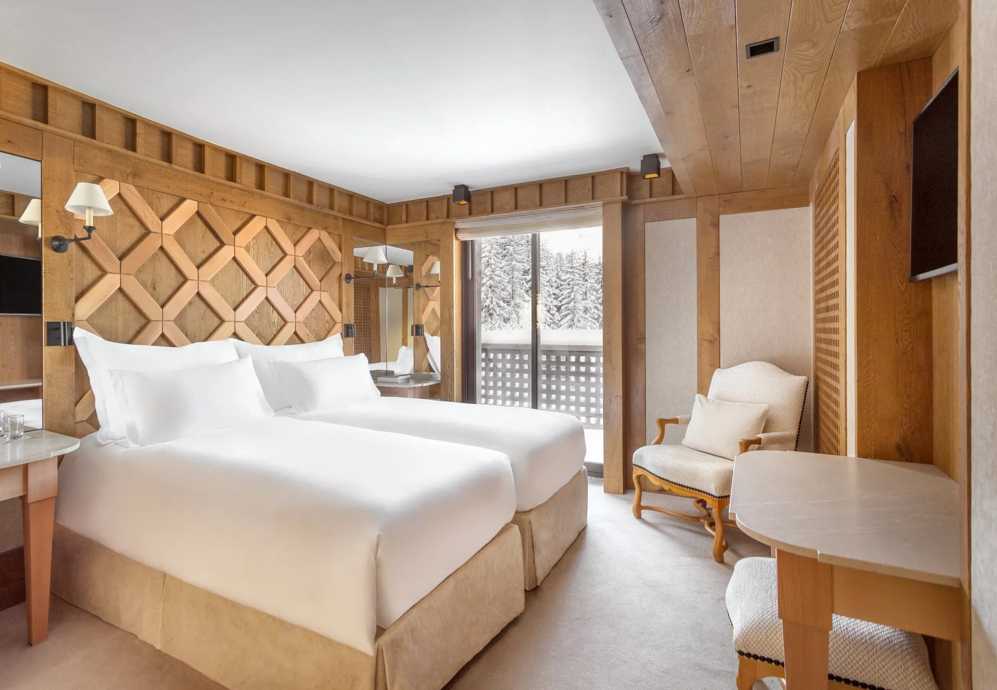 A Junior Suite at Aman Le Mélézin, with a balcony onto the snowy pines