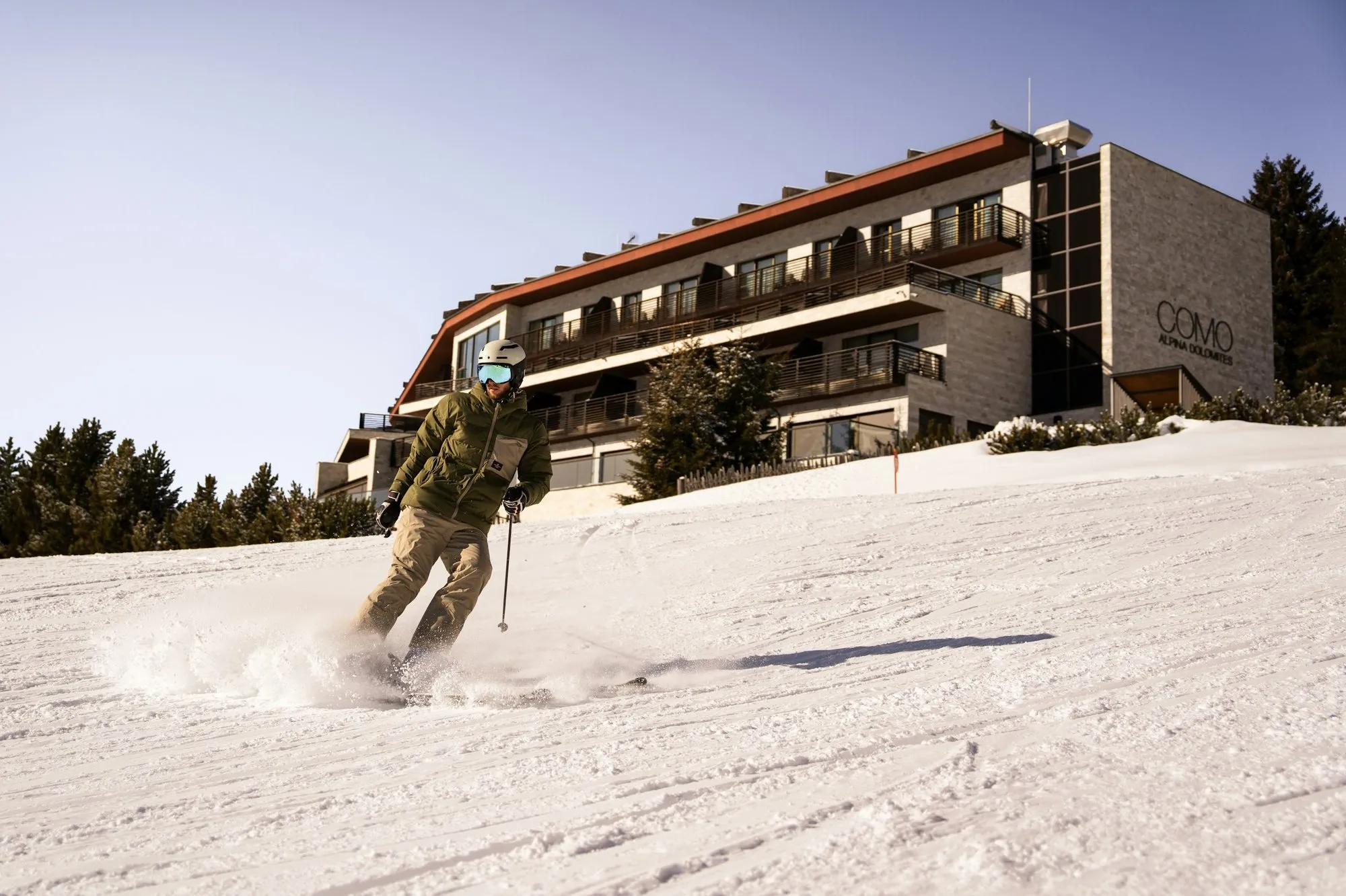 A skier on the slope in front of COMO Alpina Dolomites