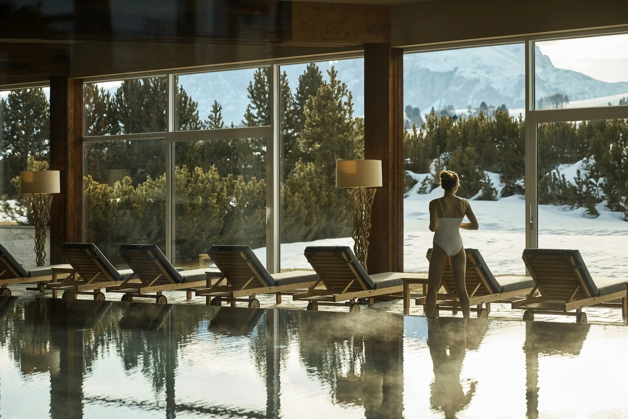The indoor pool at COMO Alpina Dolomites, with windows onto the snow