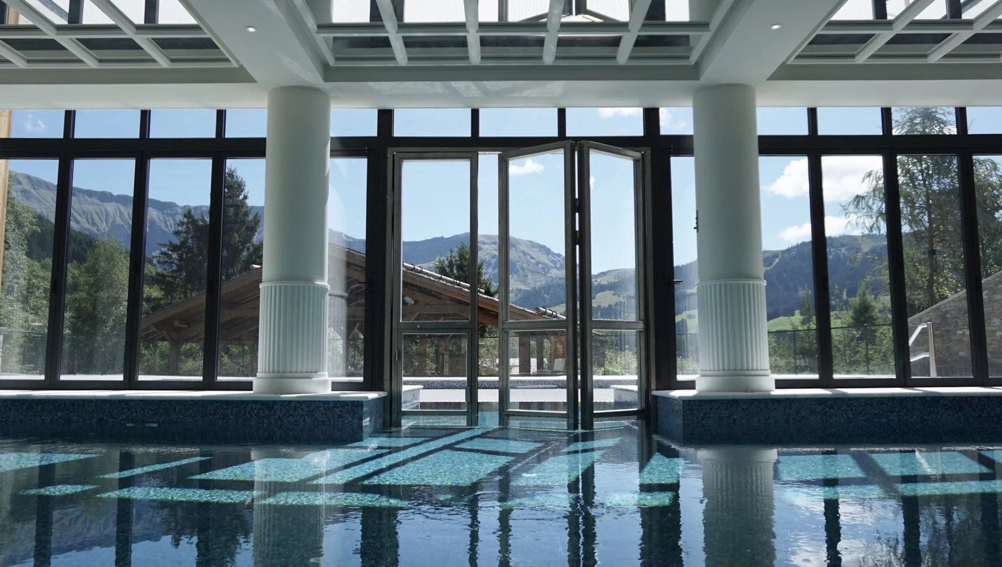 The indoor pool at Four Seasons Megève, with floor-to-ceiling windows onto the mountains