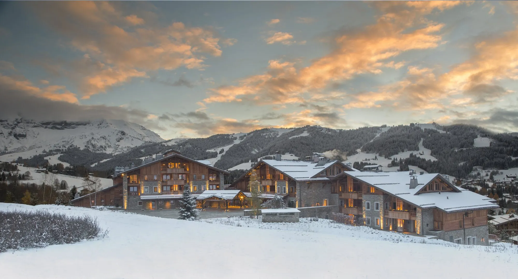 Four Seasons Megève at sunset with the snow-covered slopes behind