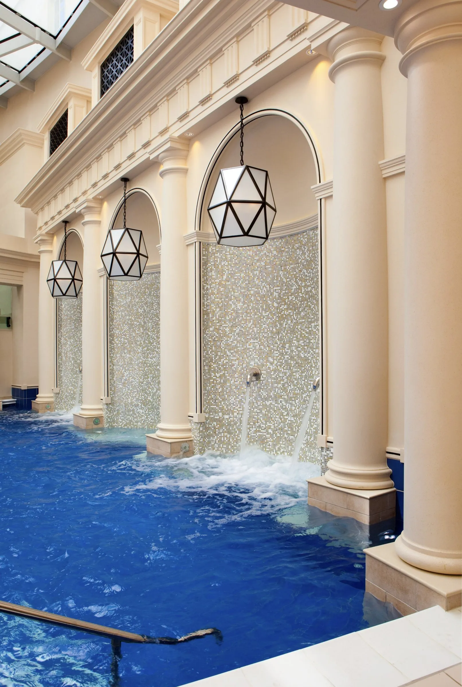 Water pouring into a thermal pool beneath arched columns