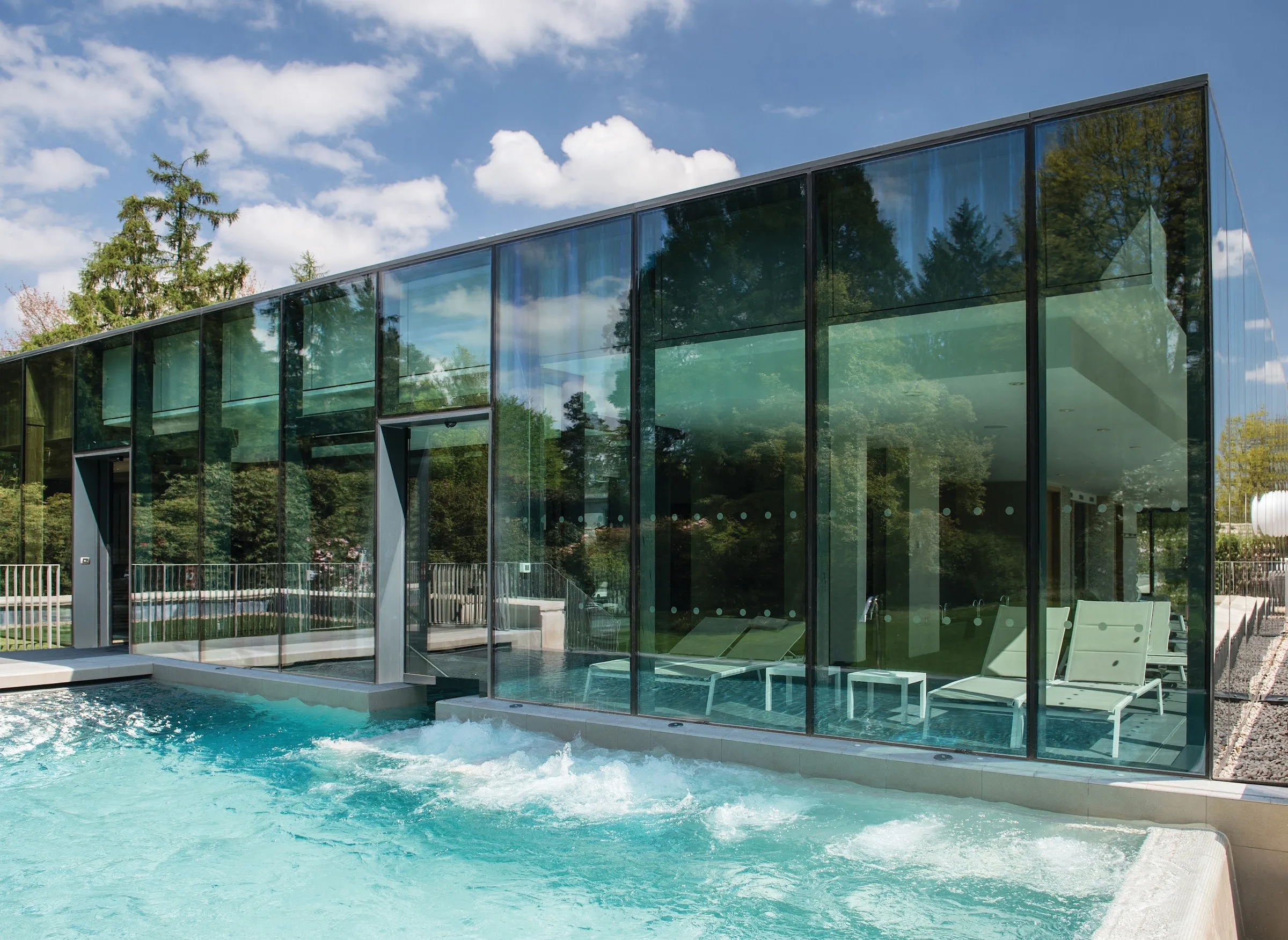 An outdoor pool beside the glass-walled spa building