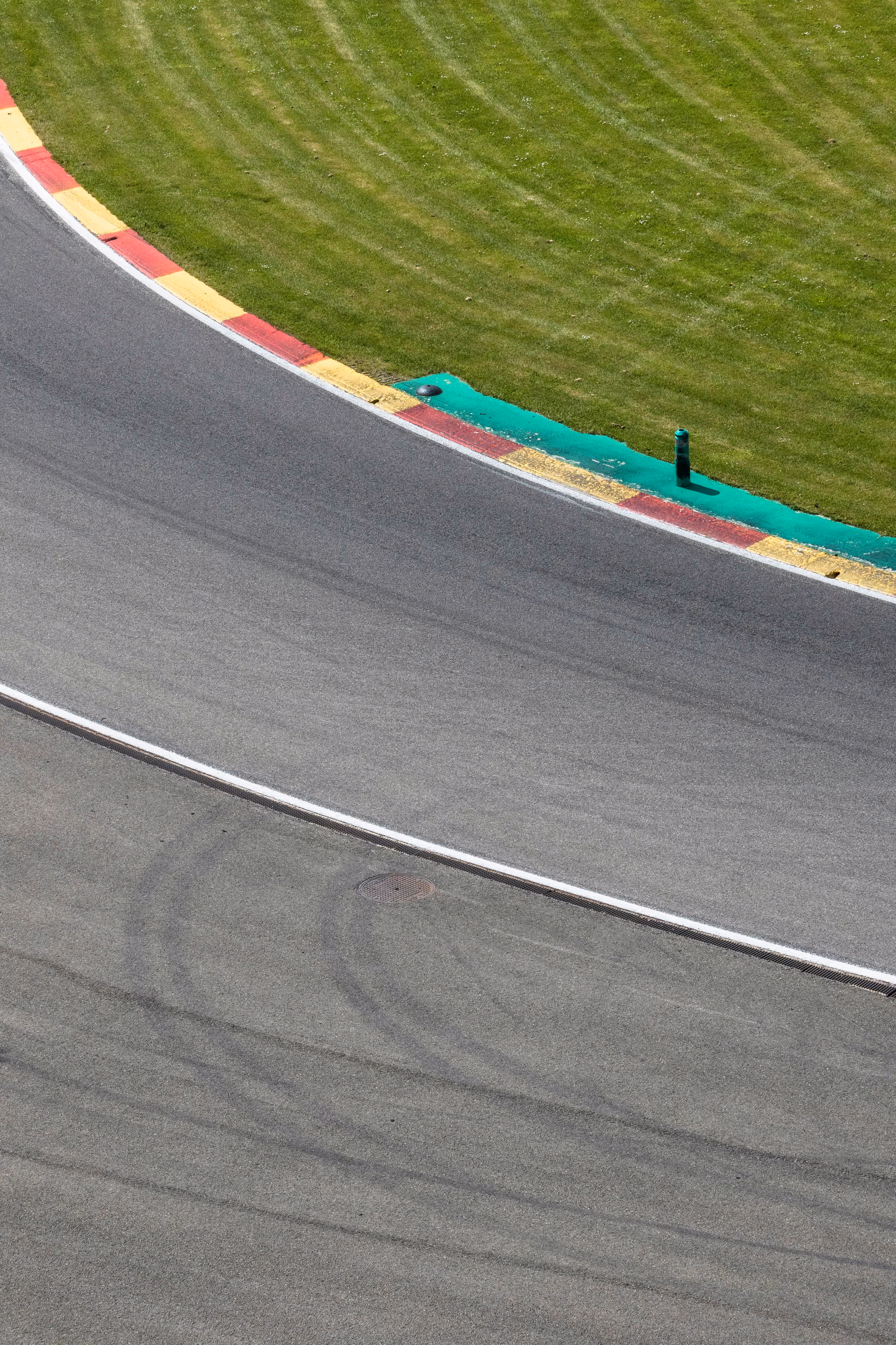 A curving section of race track with red and white kerbs