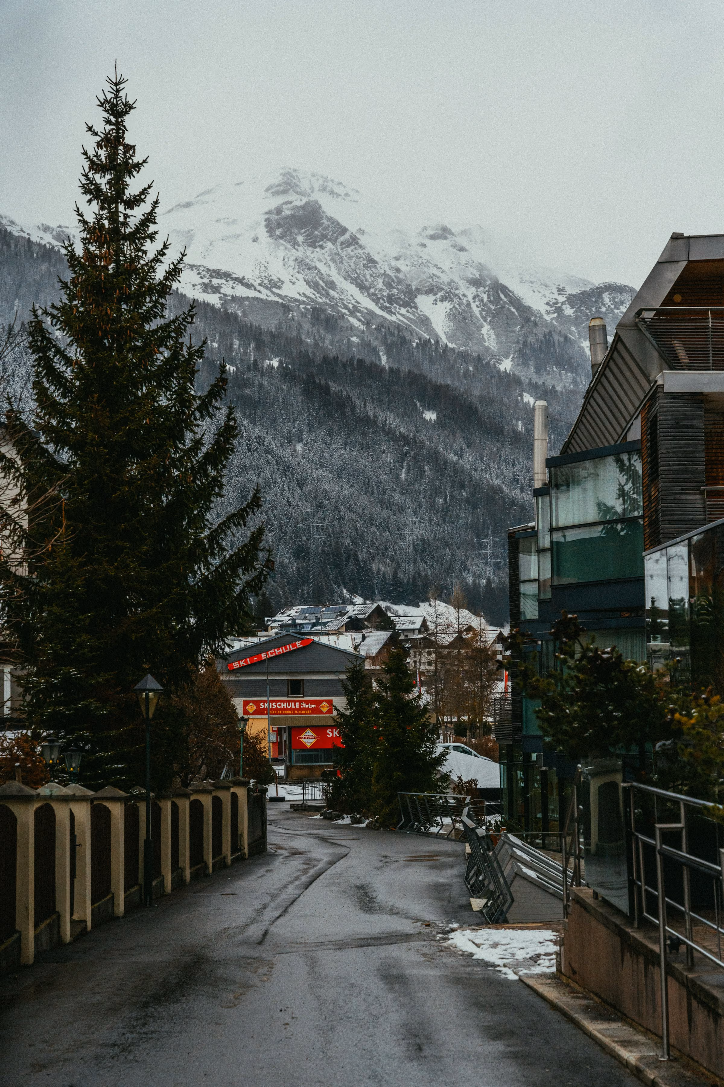 A lane through St Anton am Arlberg, chalets and snowy peaks behind
