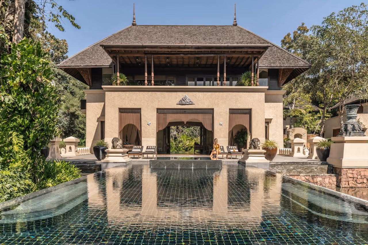 A two-storey Lanna-style pavilion behind a long reflecting pool at Four Seasons Resort Chiang Mai