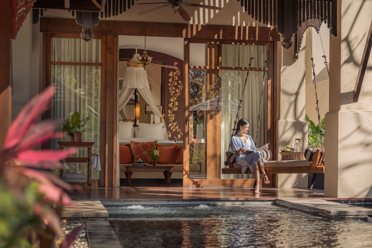 A guest on a swing seat on a pavilion terrace with its own plunge pool at Four Seasons Resort Chiang Mai