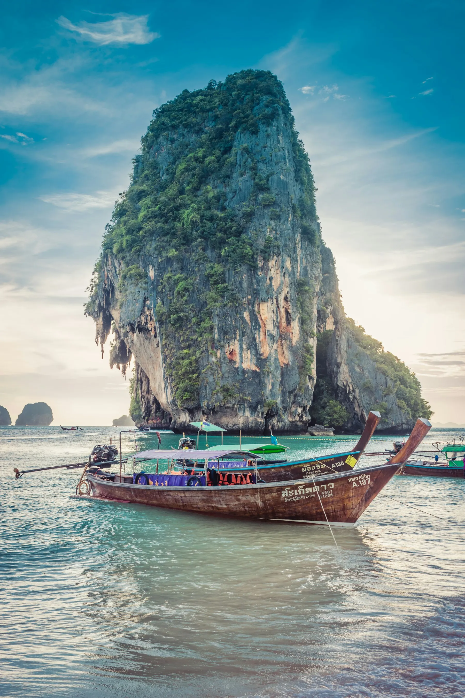 A longtail boat beneath a limestone karst at Railay, Krabi, at the best time to visit Thailand's Andaman coast