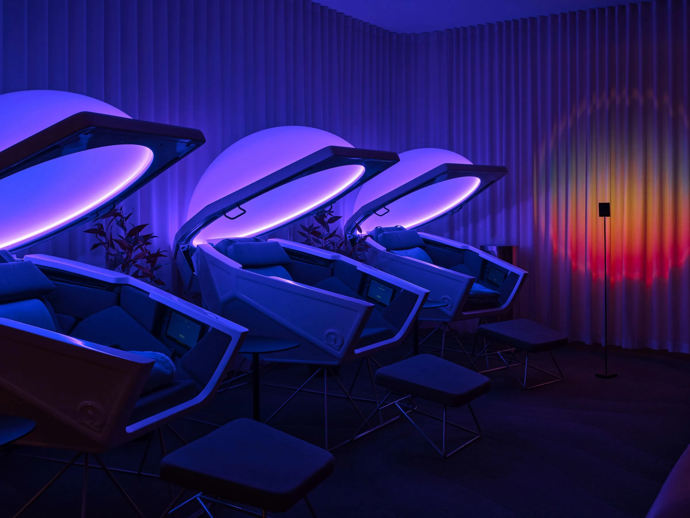 Somadome meditation pods glowing purple in the Clubhouse