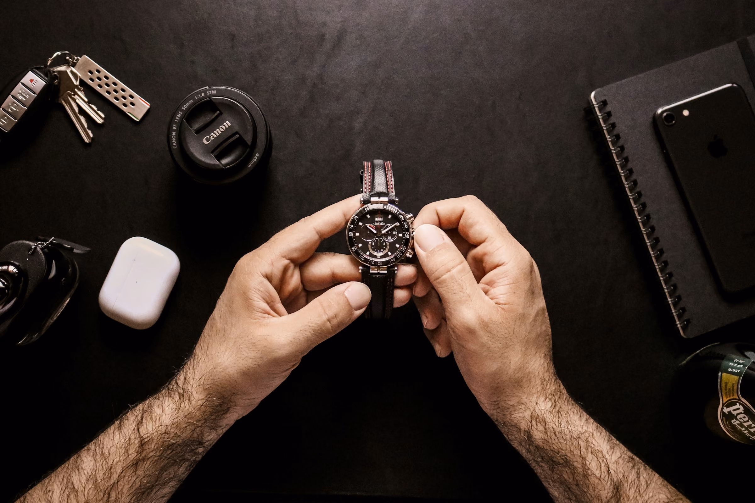 Hands holding a watch on a desk, the kind of photo worth taking before you insure it