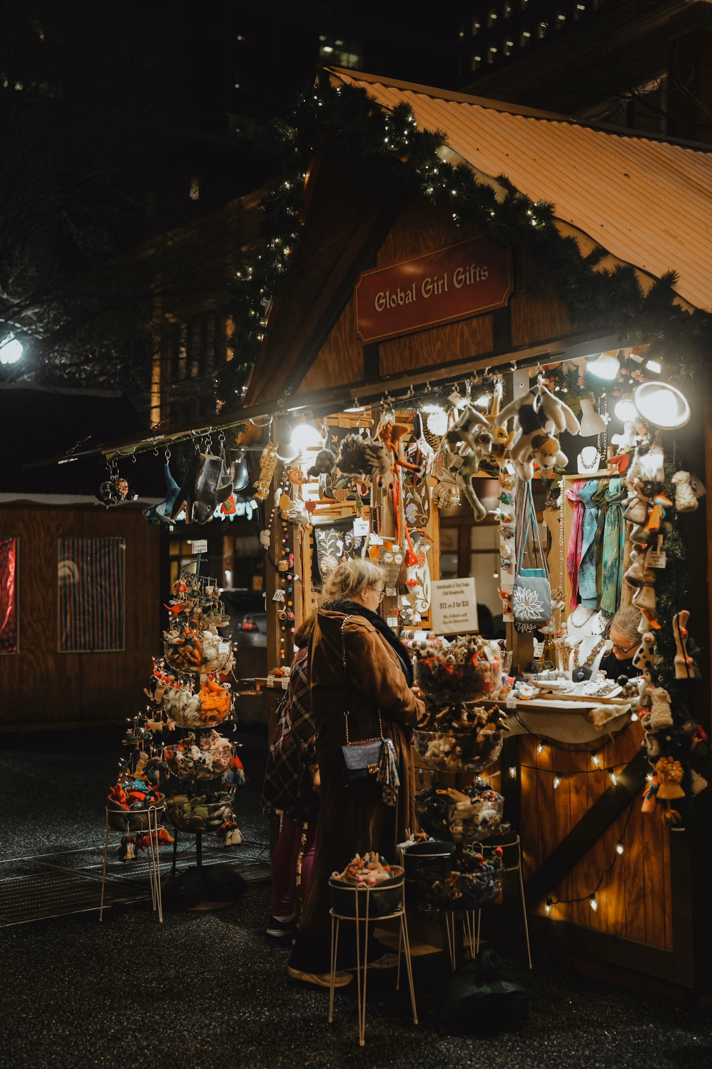 Browsing a lit Christmas market stall