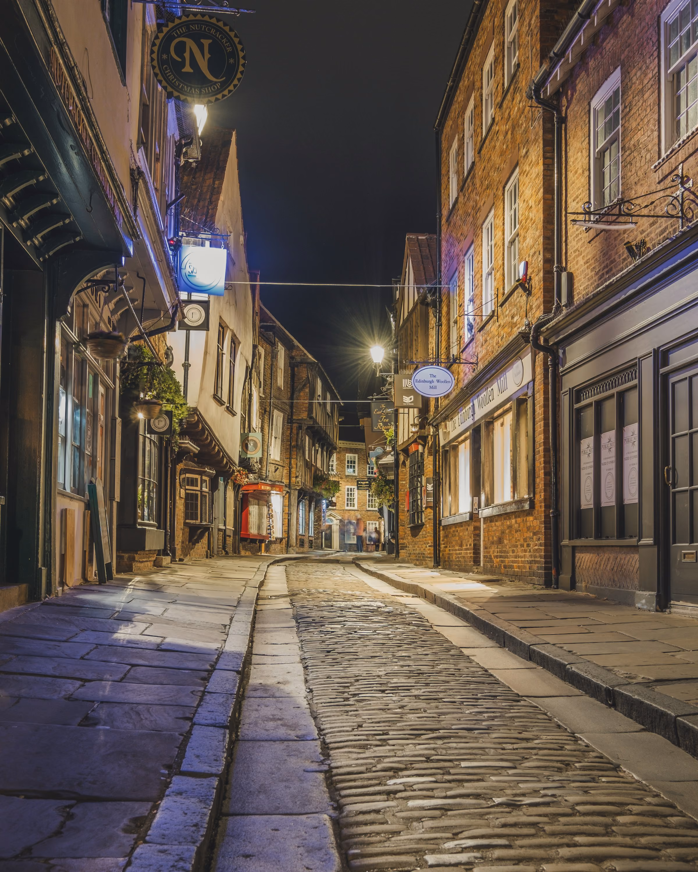 A cobbled York street at night under warm lamps