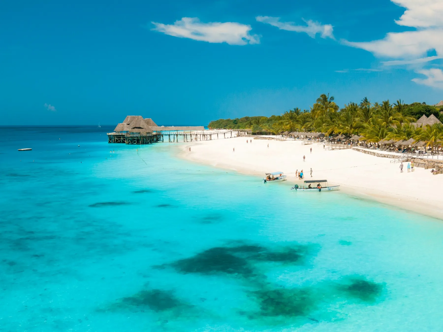 White sand, a thatched pier and turquoise water on Zanzibar's coast in the dry season, the best time to visit Zanzibar